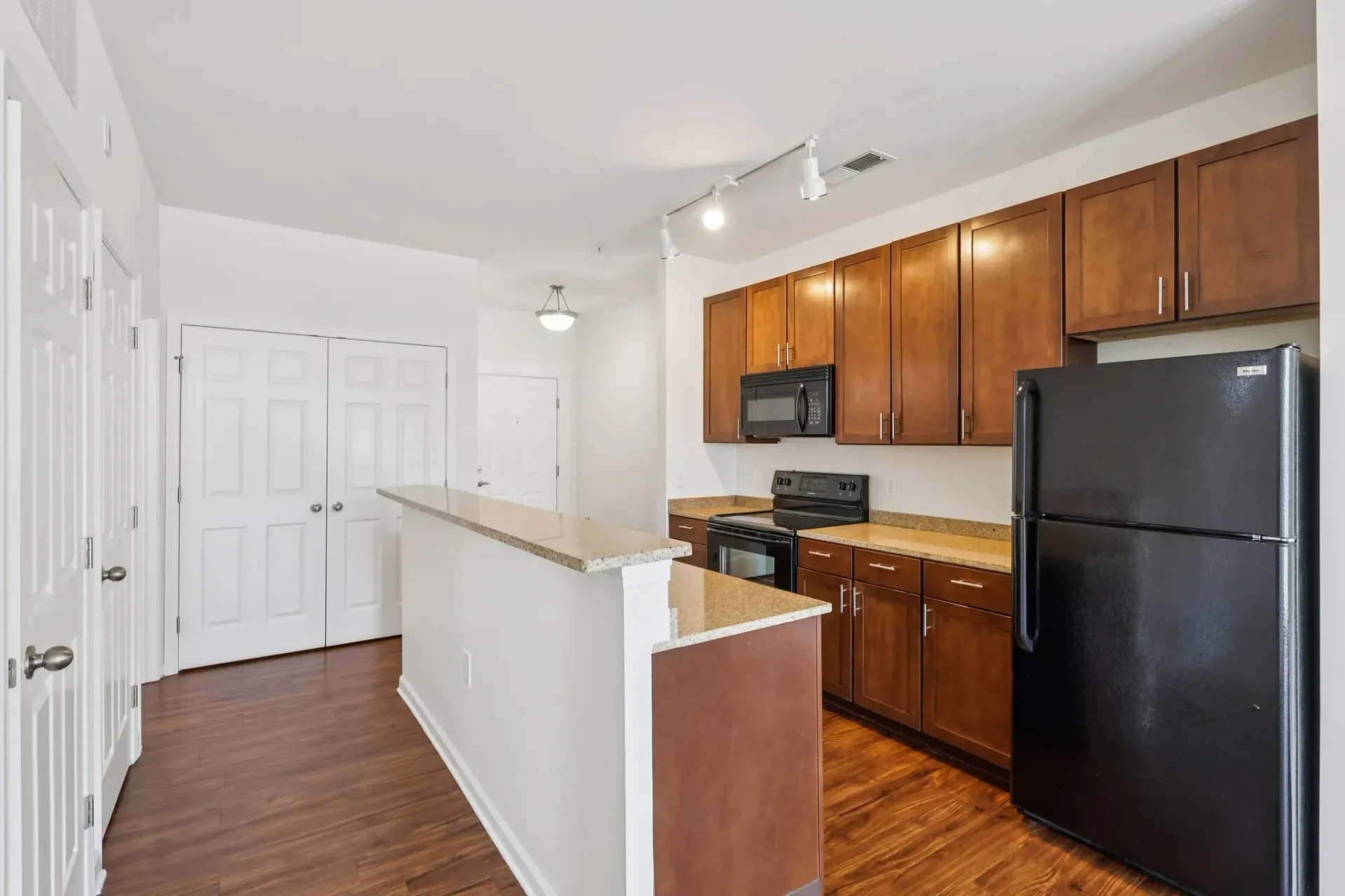 Modern kitchen with dark wood cabinets, granite countertops, stainless steel appliances, and a breakfast bar at Catherine 36 Apartments for rent in Charlotte, NC