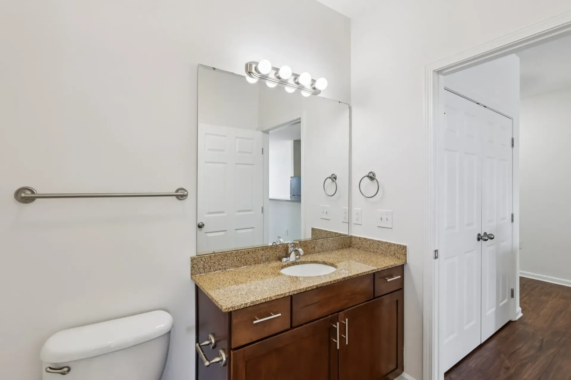 Bathroom vanity with granite countertop, sink, mirror, and toilet at Catherine 36 Apartments for rent in Charlotte, NC