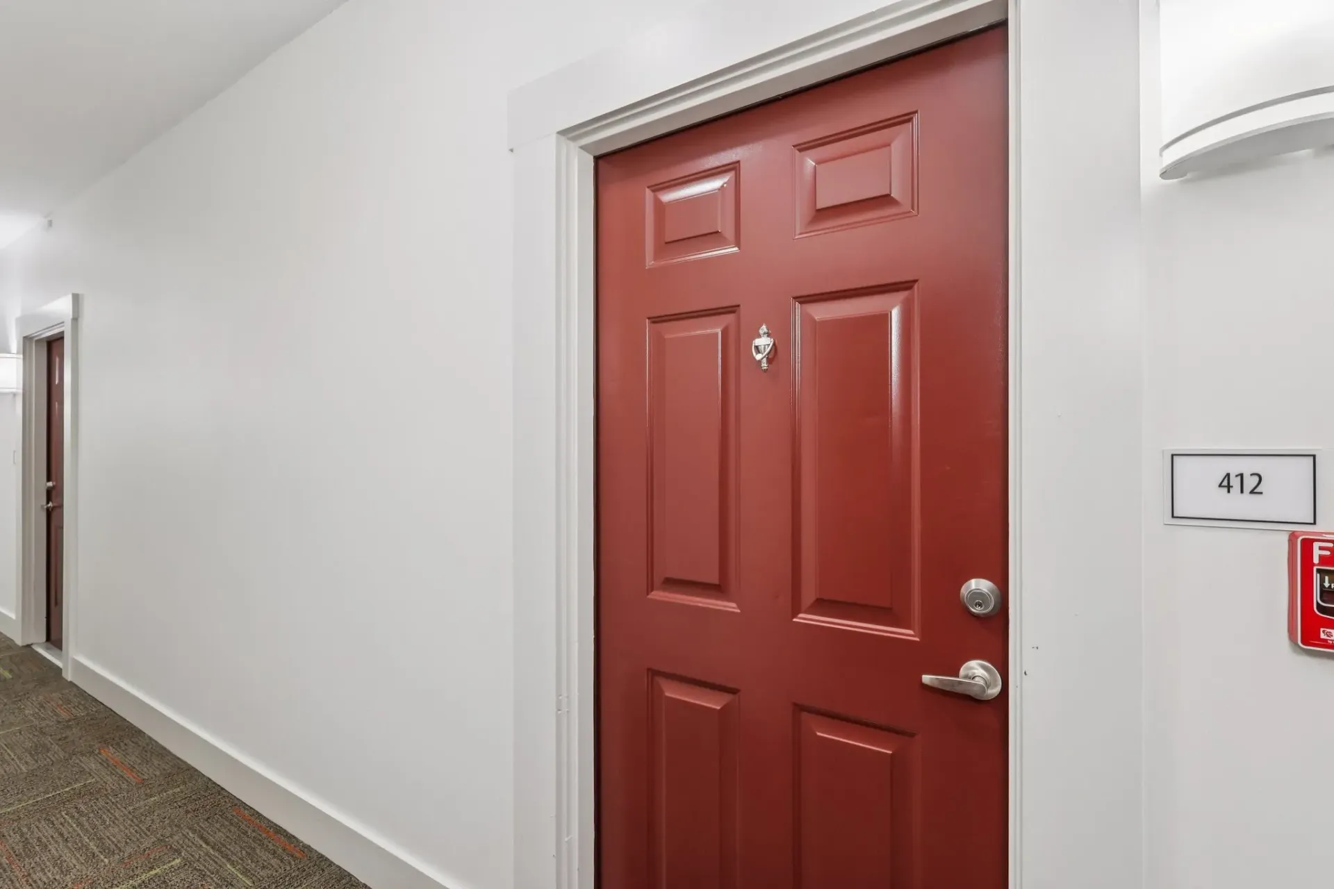 Hallway with red apartment doors and room number 412 at Catherine 36 Apartments for rent in Charlotte, NC