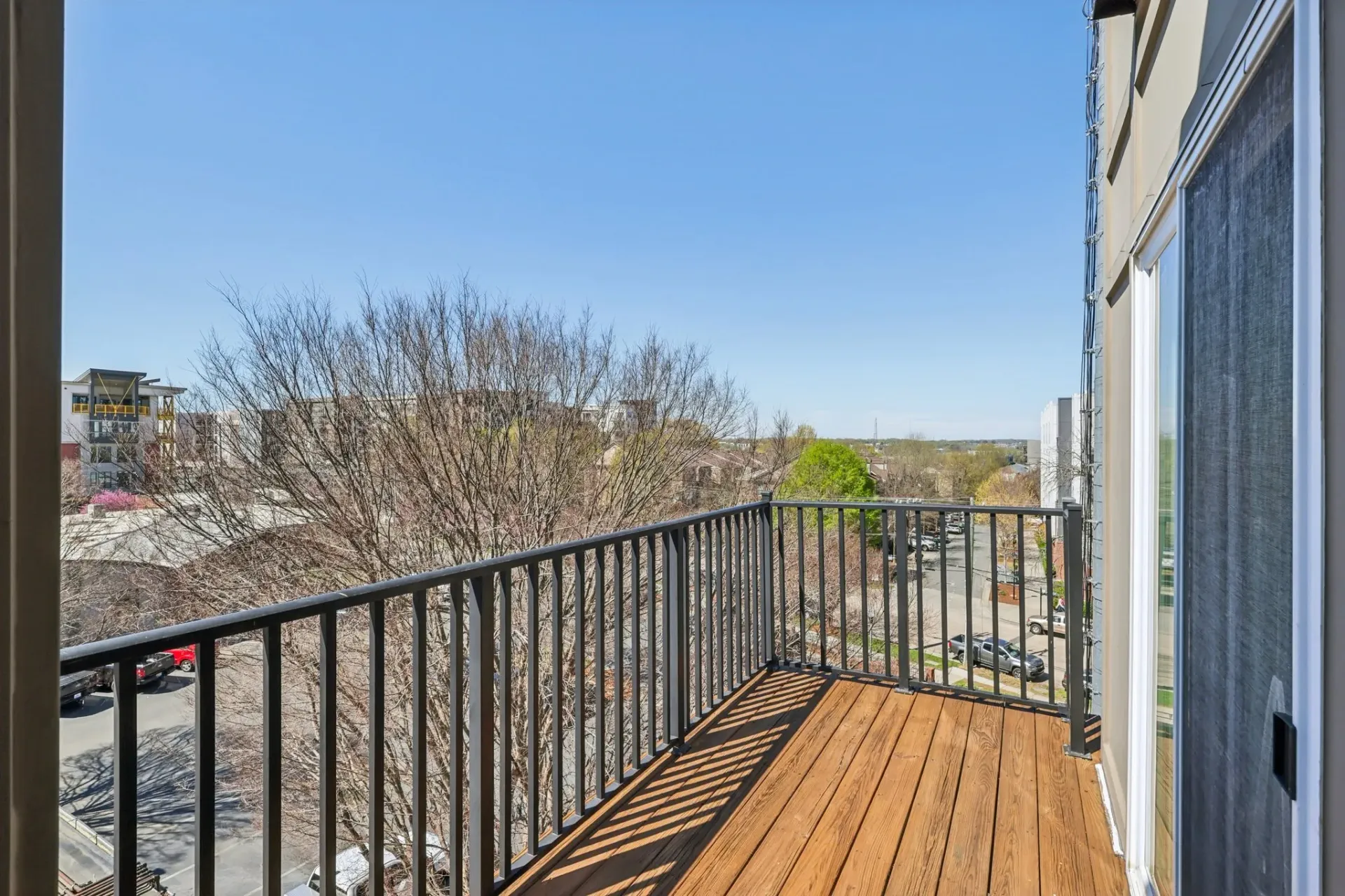 Balcony with wooden floor and railing overlooking the city at Catherine 36 Apartments for rent in Charlotte, NC