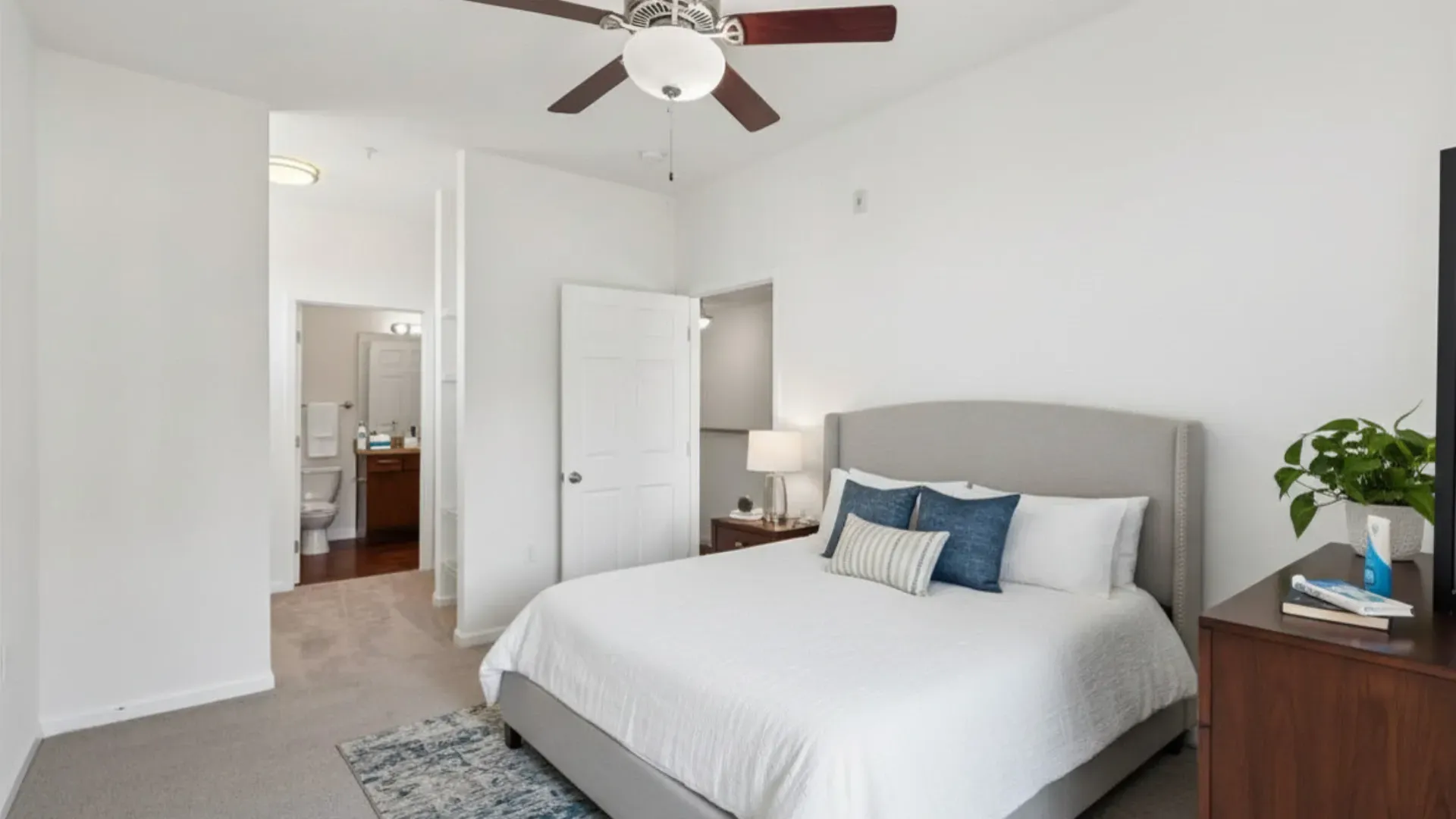Bedroom with king-size bed, ceiling fan, and access to bathroom at Catherine 36 Apartments for rent in Charlotte, NC.