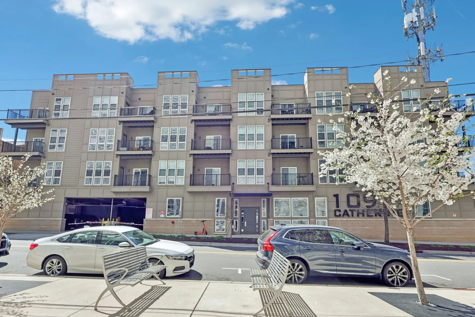 Apartment building exterior with balconies and cars parked out front at Catherine 36 Apartments for rent in Charlotte, NC.