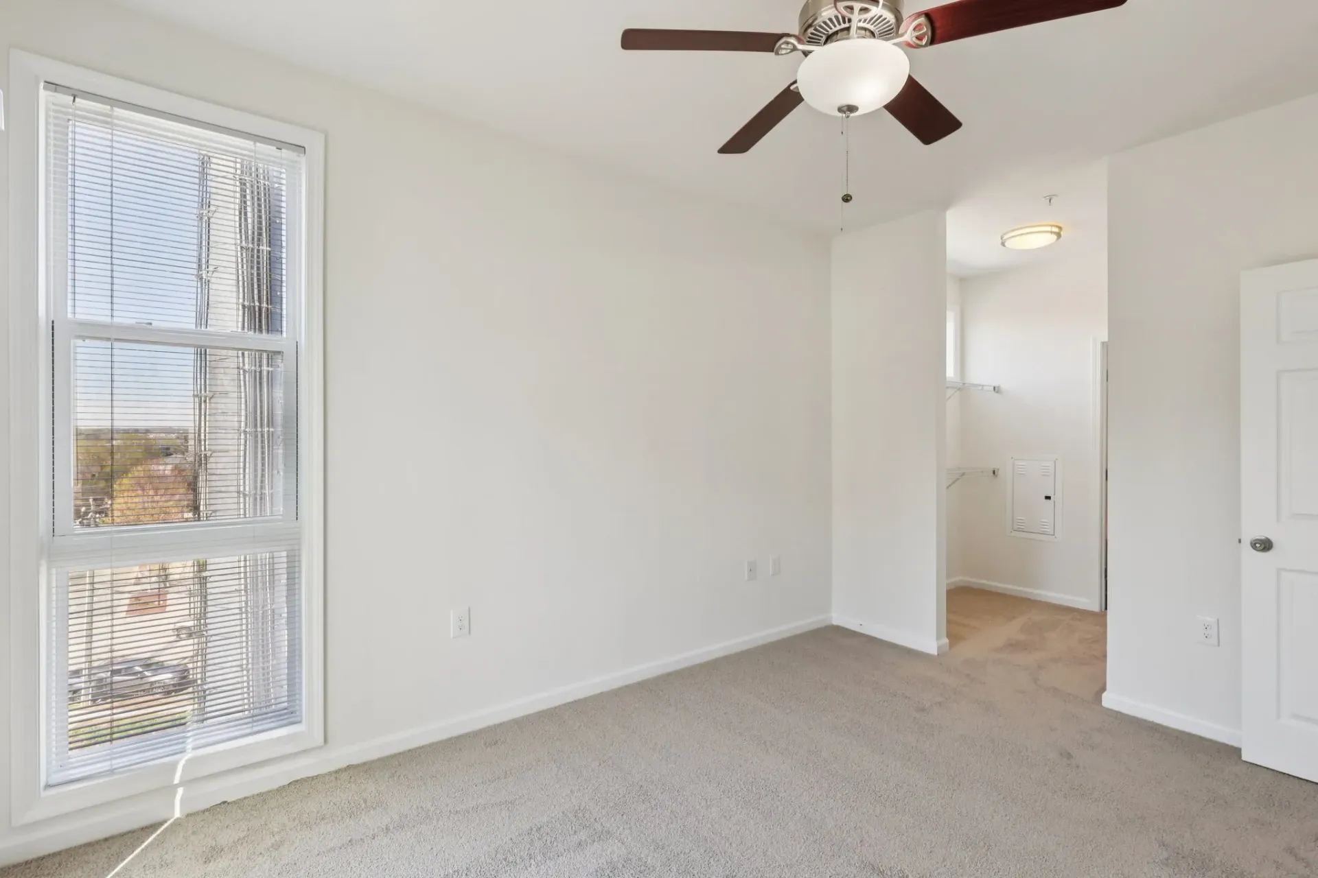 Bedroom with a ceiling fan, large window, and closet entrance at Catherine 36 Apartments for rent in Charlotte, NC