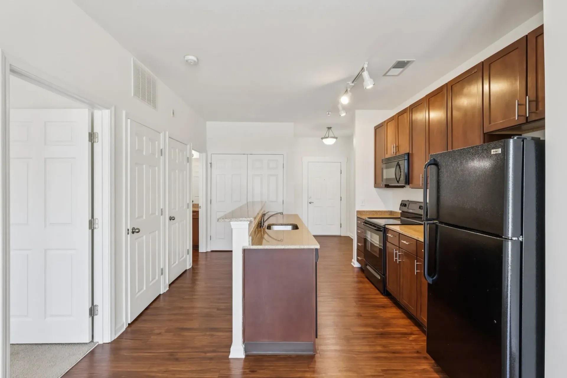 Modern kitchen with dark wood cabinets, granite countertops, stainless steel appliances, and an island at Catherine 36 Apartments for rent in Charlotte, NC