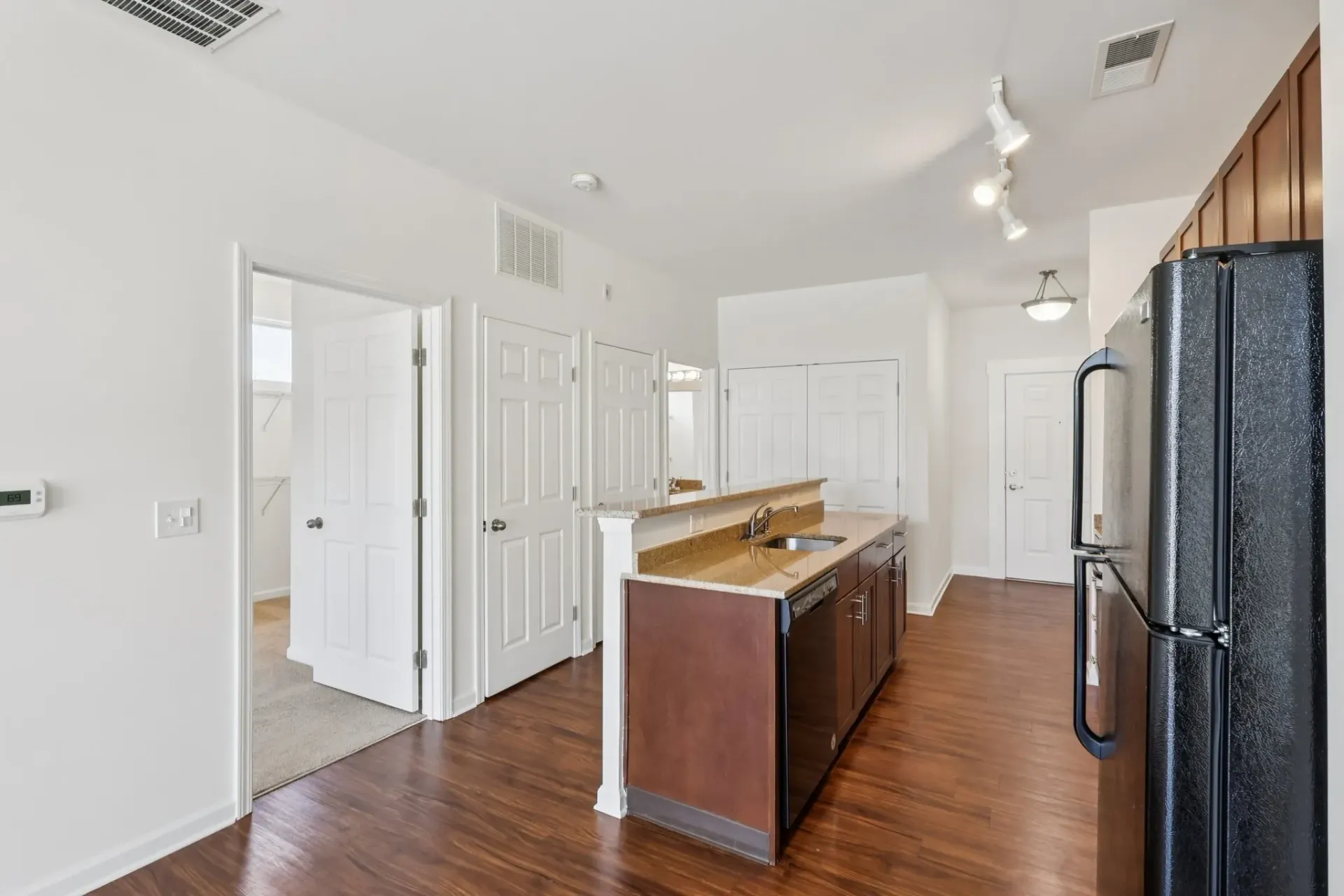 Modern kitchen with dark wood cabinets, granite countertops, and stainless steel appliances at Catherine 36 Apartments for rent in Charlotte, NC