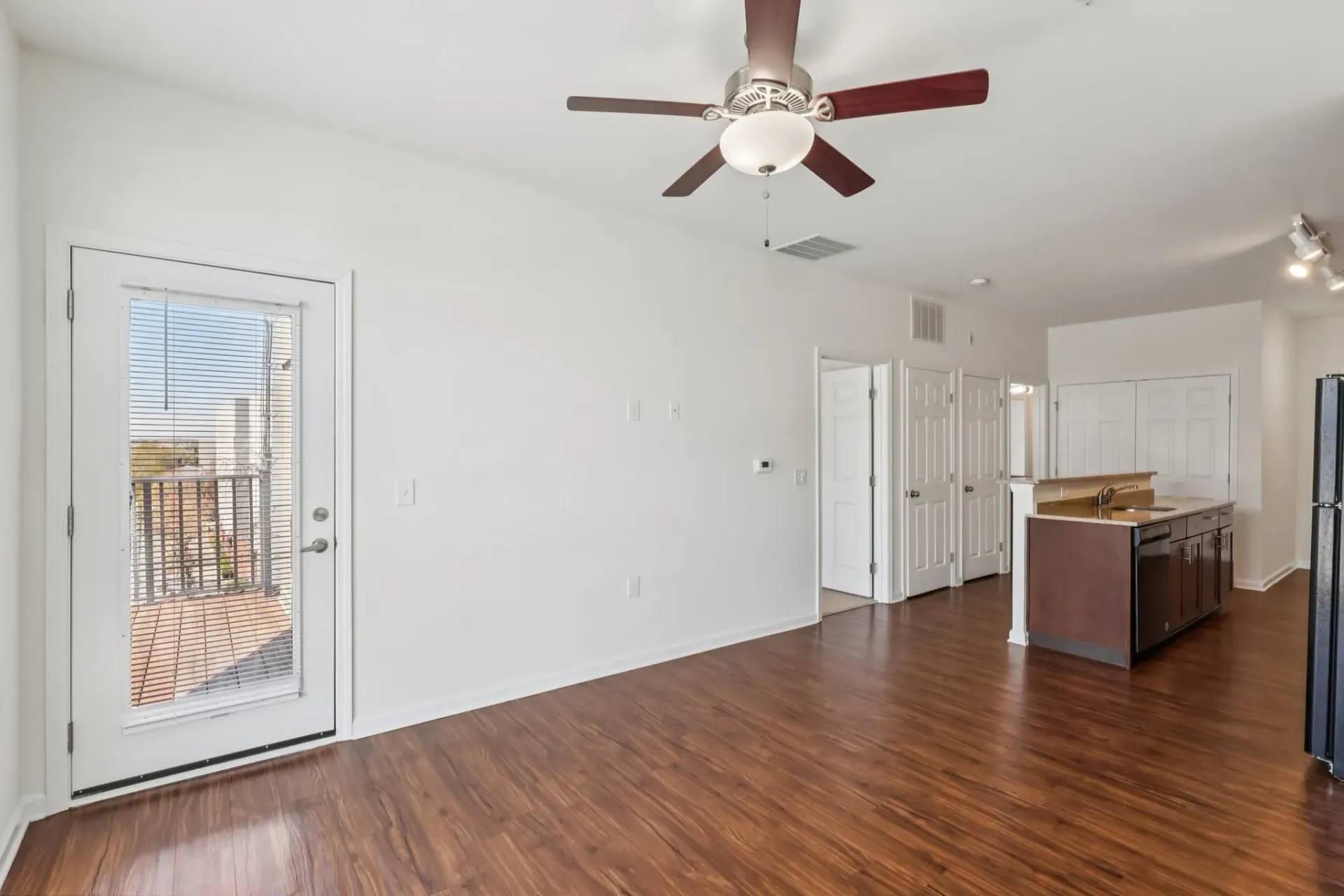 Living room and kitchen area with a ceiling fan, sliding glass door to balcony, and island counter at Catherine 36 Apartments for rent in Charlotte, NC