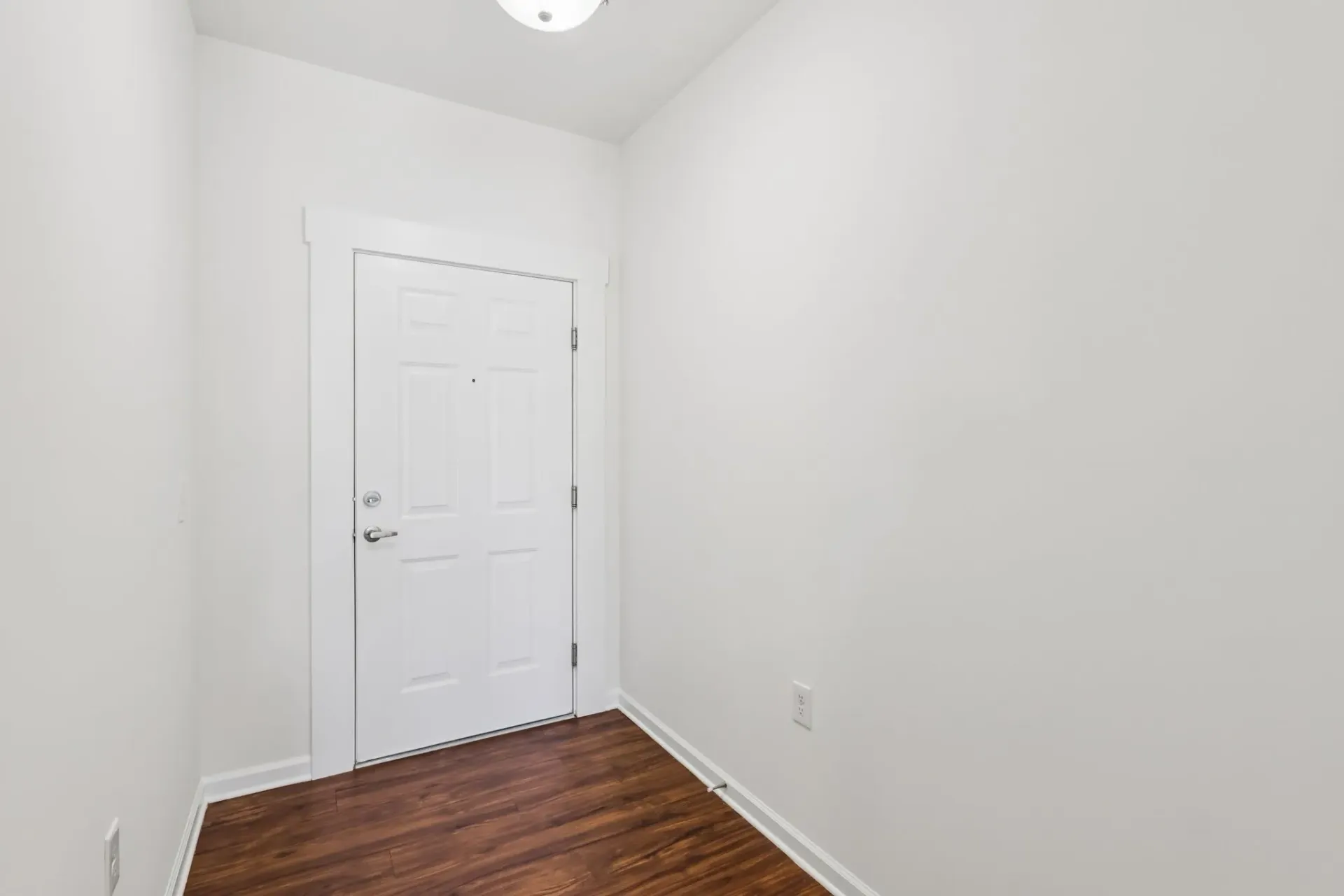 Interior view of an apartment entrance door with white walls and a wooden floor at Catherine 36 Apartments for rent in Charlotte, NC