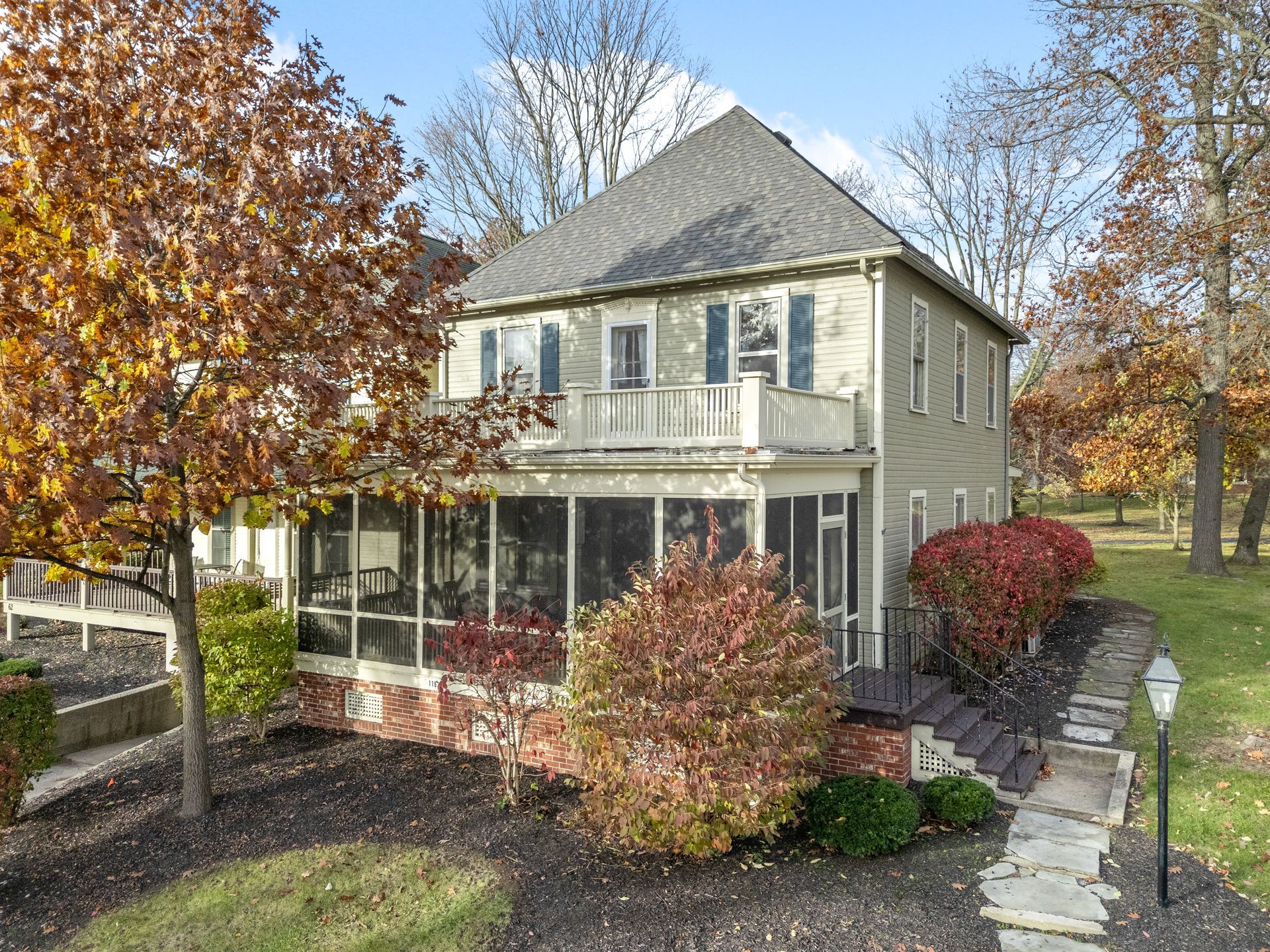 A large house with a screened in porch and a walkway leading to it.