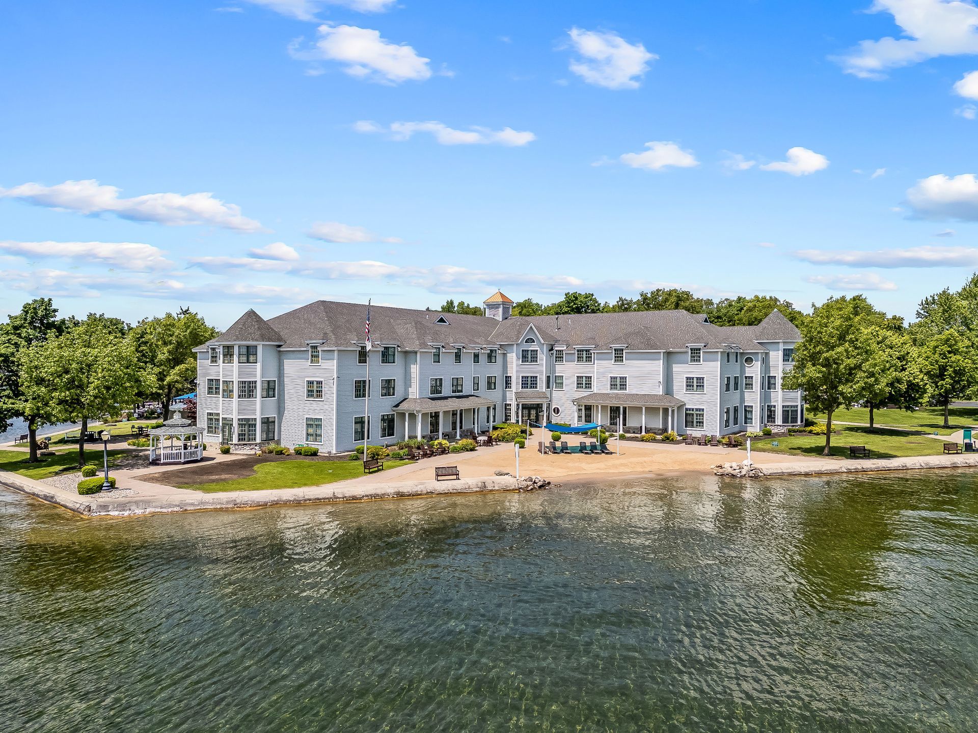 An aerial view of a large white building next to a body of water.