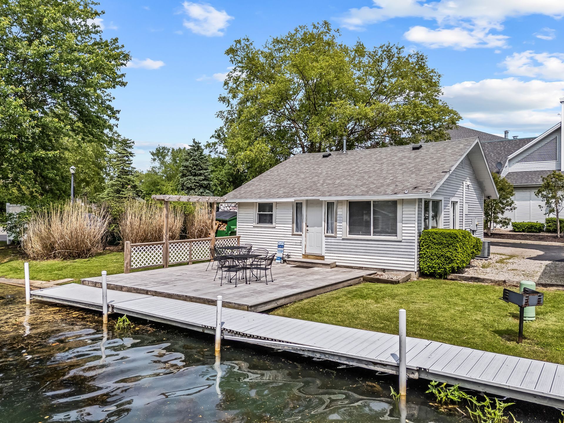 A small white house with a dock in front of it.