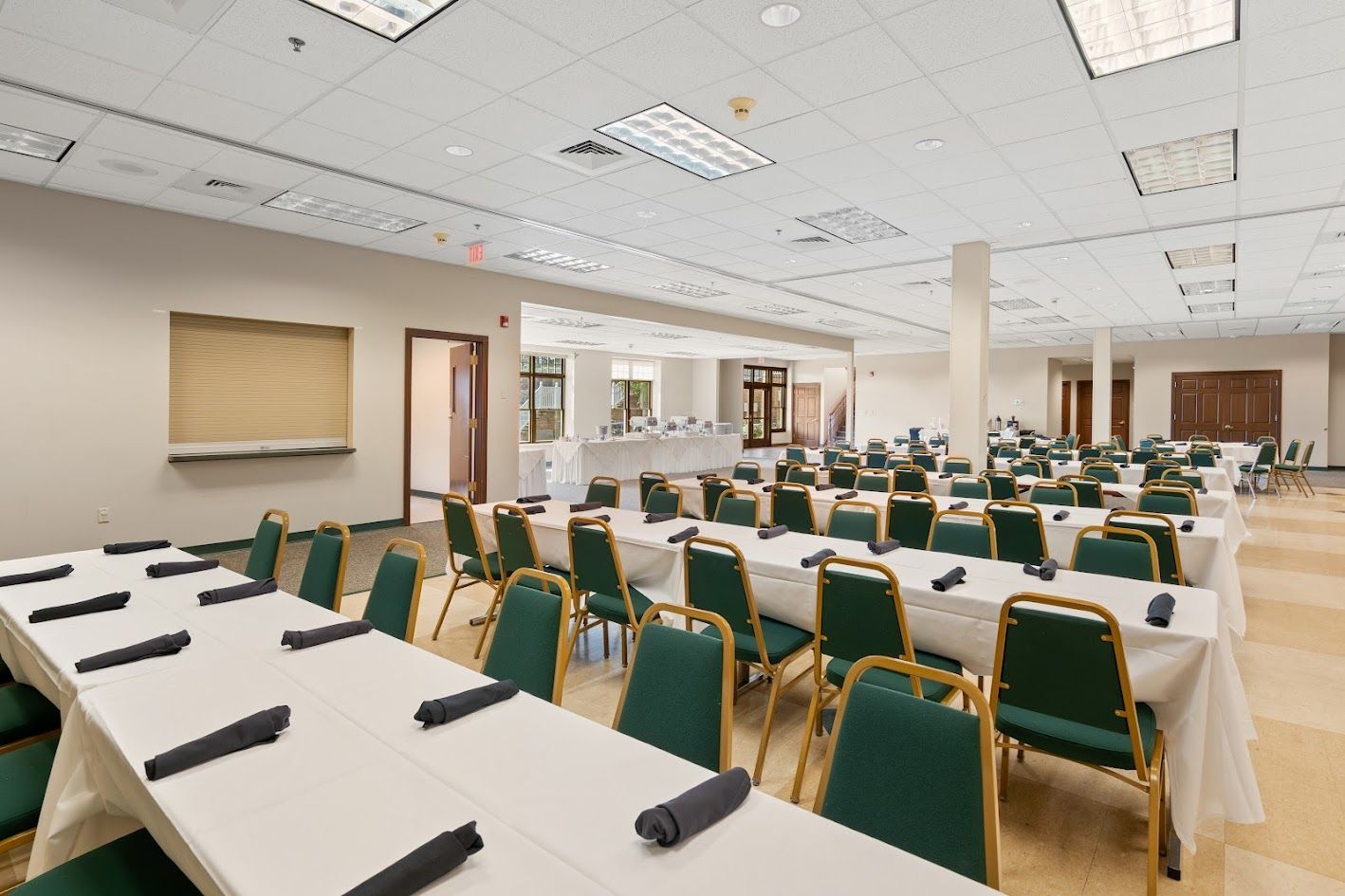 A large room with tables and chairs set up for a meeting.