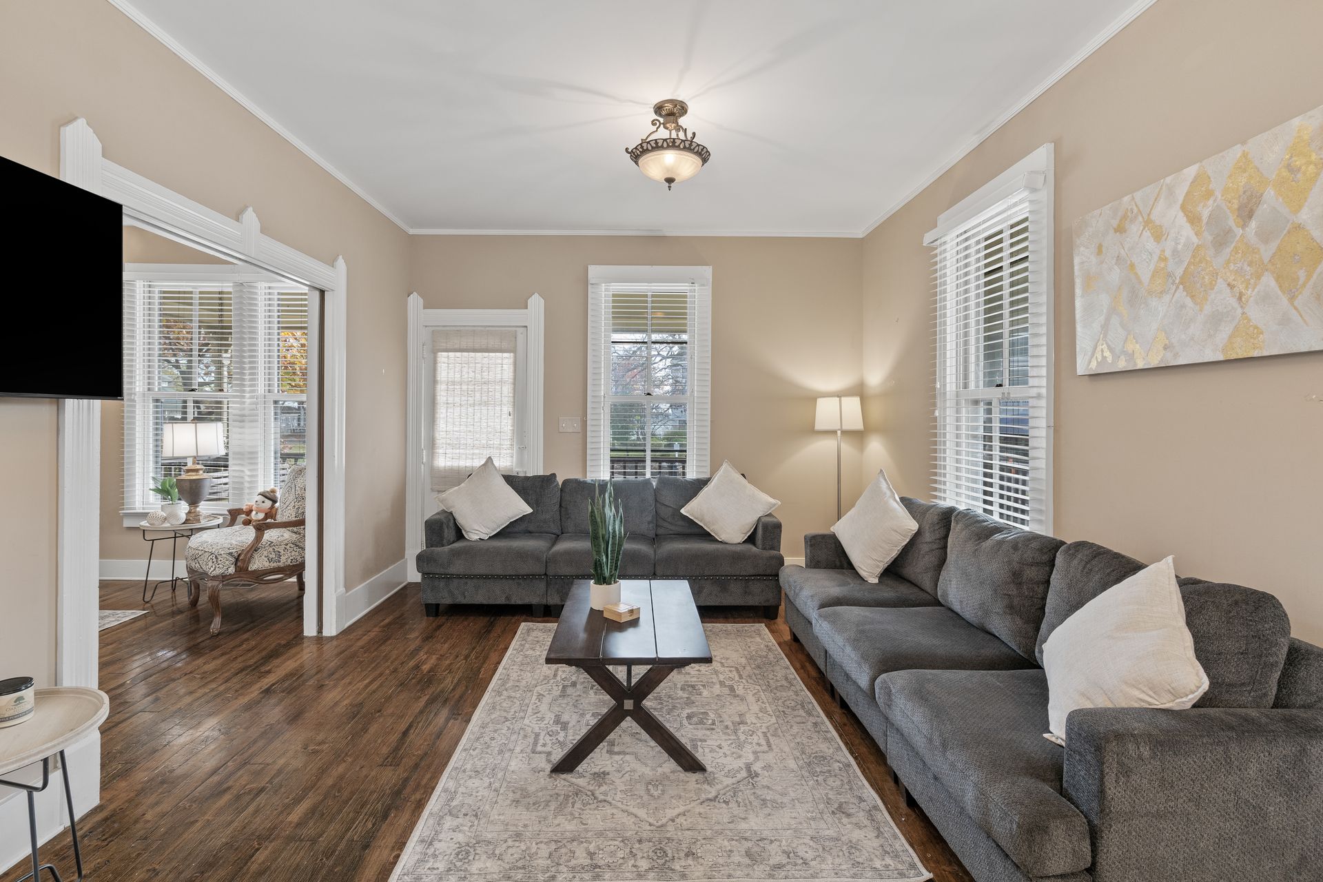 A living room with two couches , a coffee table , and a flat screen tv.