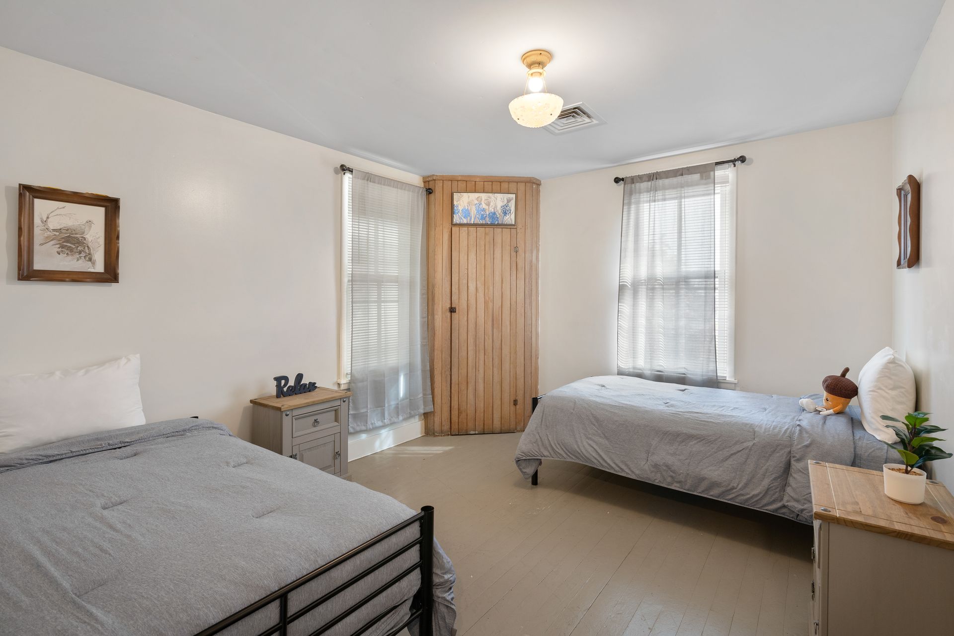 A bedroom with two beds and a wooden door.