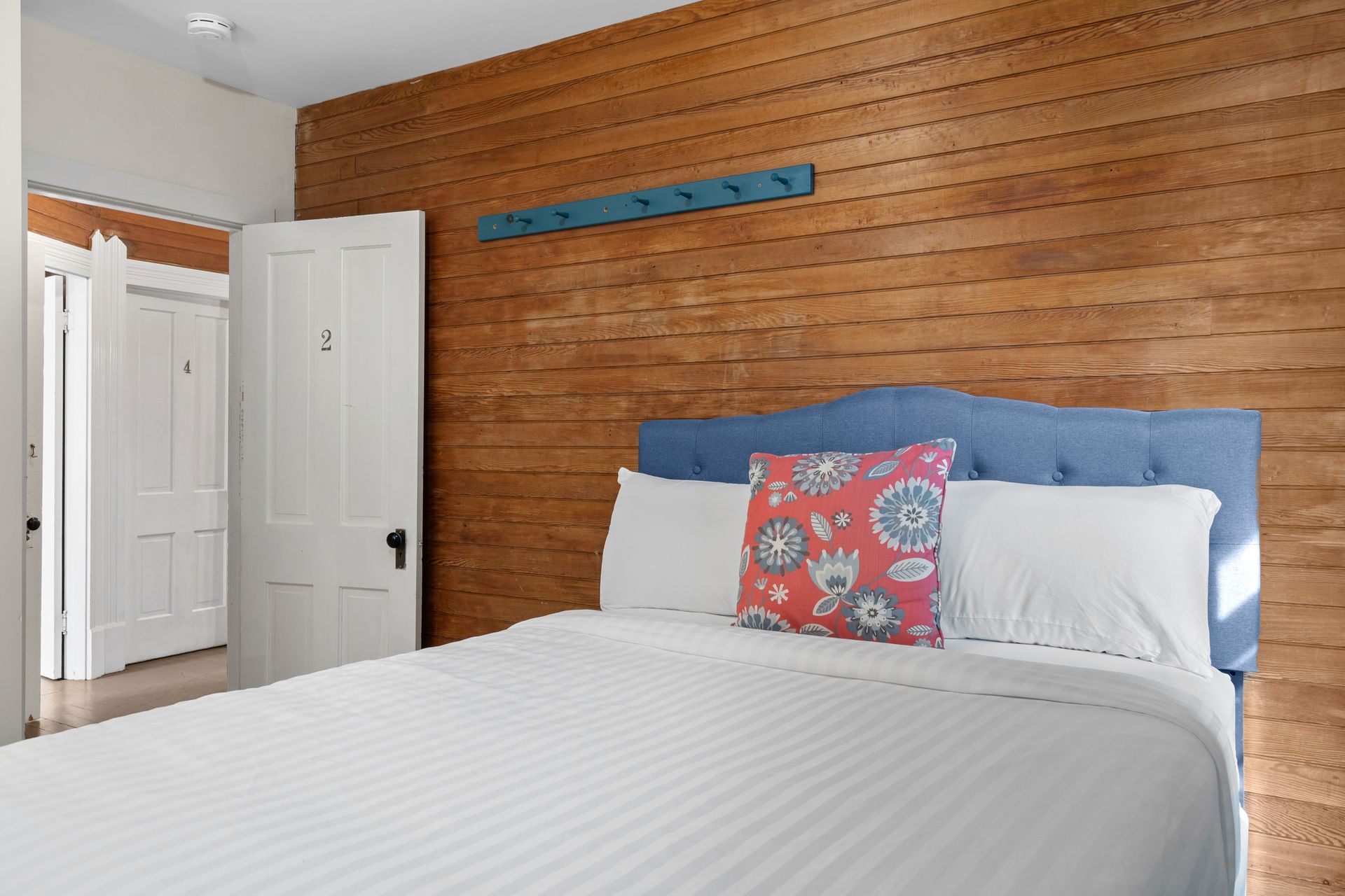 A bedroom with a bed and a wooden wall.