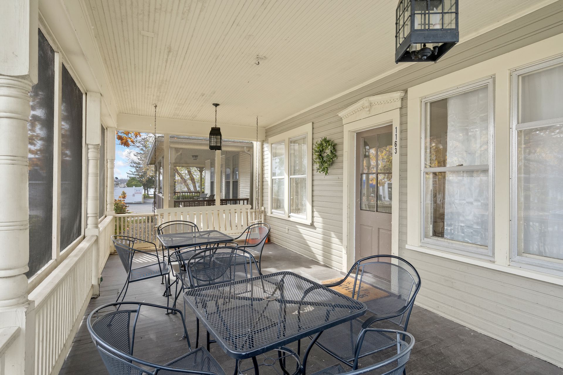 A porch with a table and chairs on it.