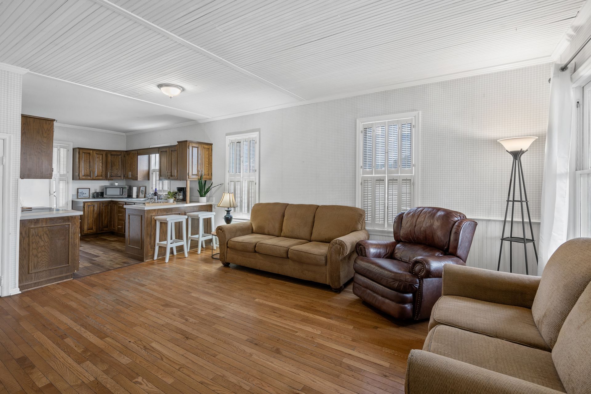 A living room with a couch , chair , and lamp.