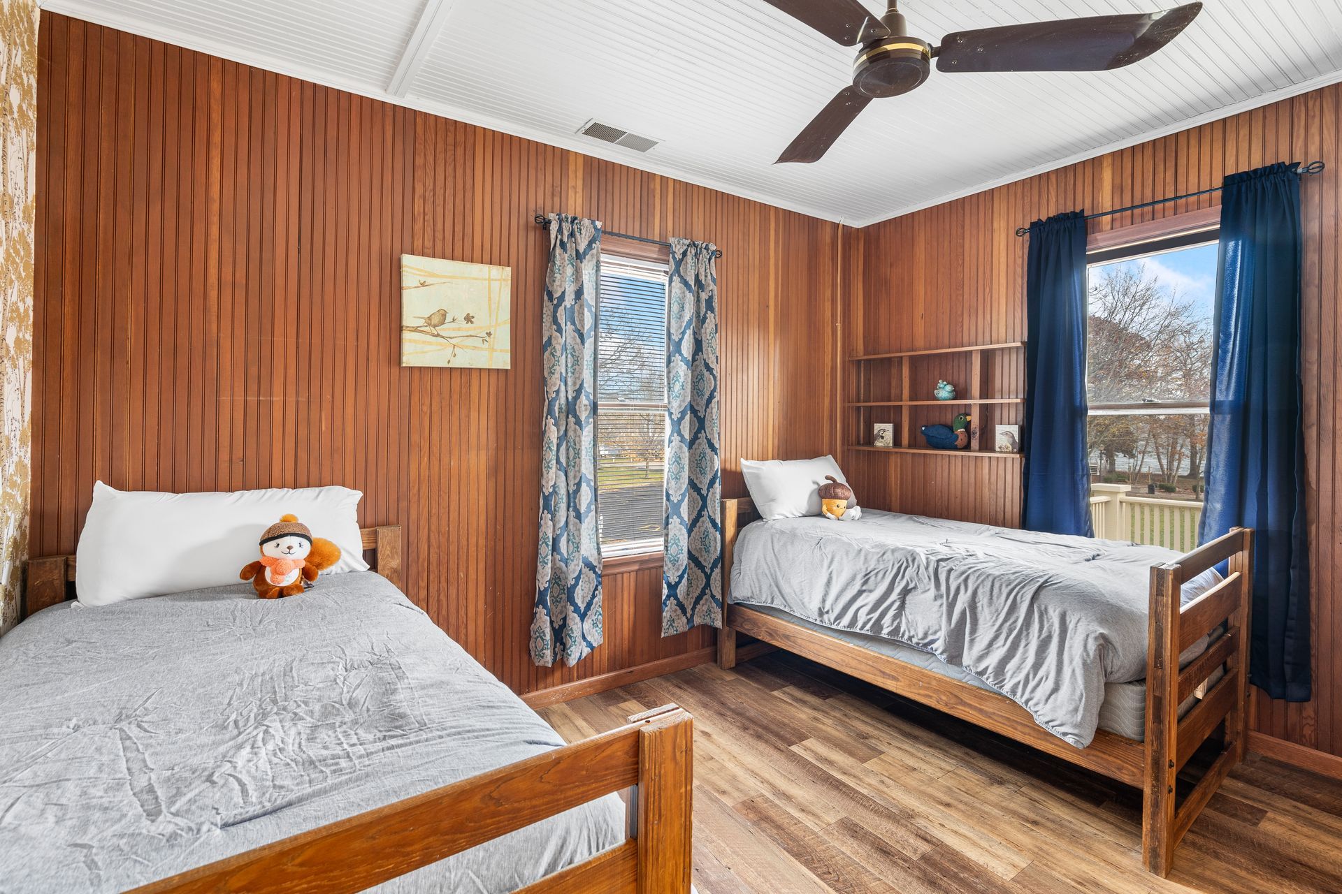 A bedroom with two beds and a ceiling fan.