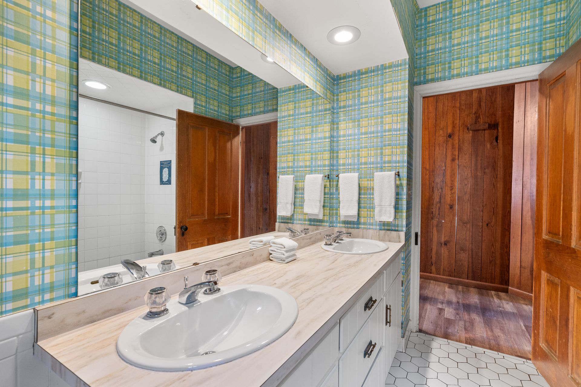 A bathroom with two sinks and a large mirror.