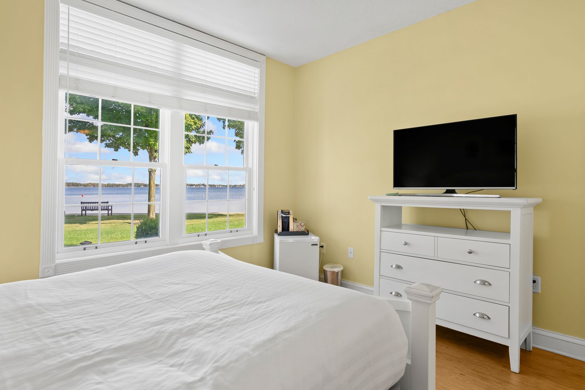 A bedroom with a bed , dresser , and television.