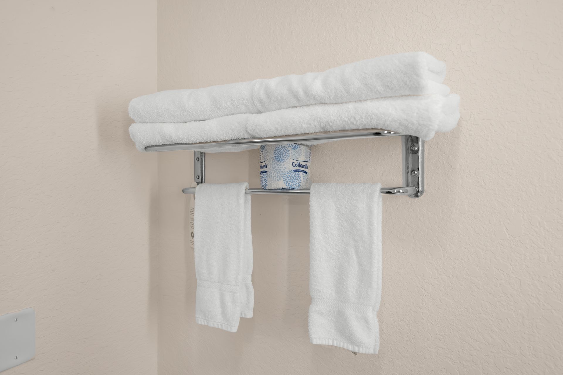 Two white towels are hanging on a towel rack in a bathroom.