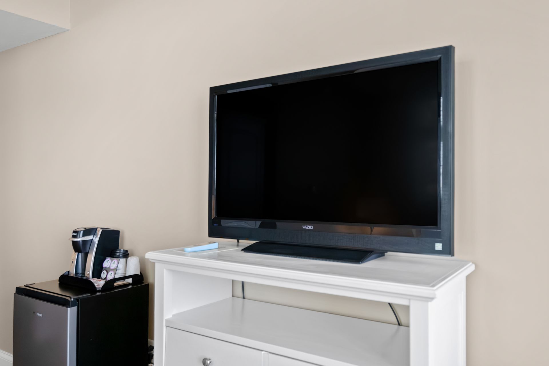 A flat screen tv is sitting on top of a white entertainment center.