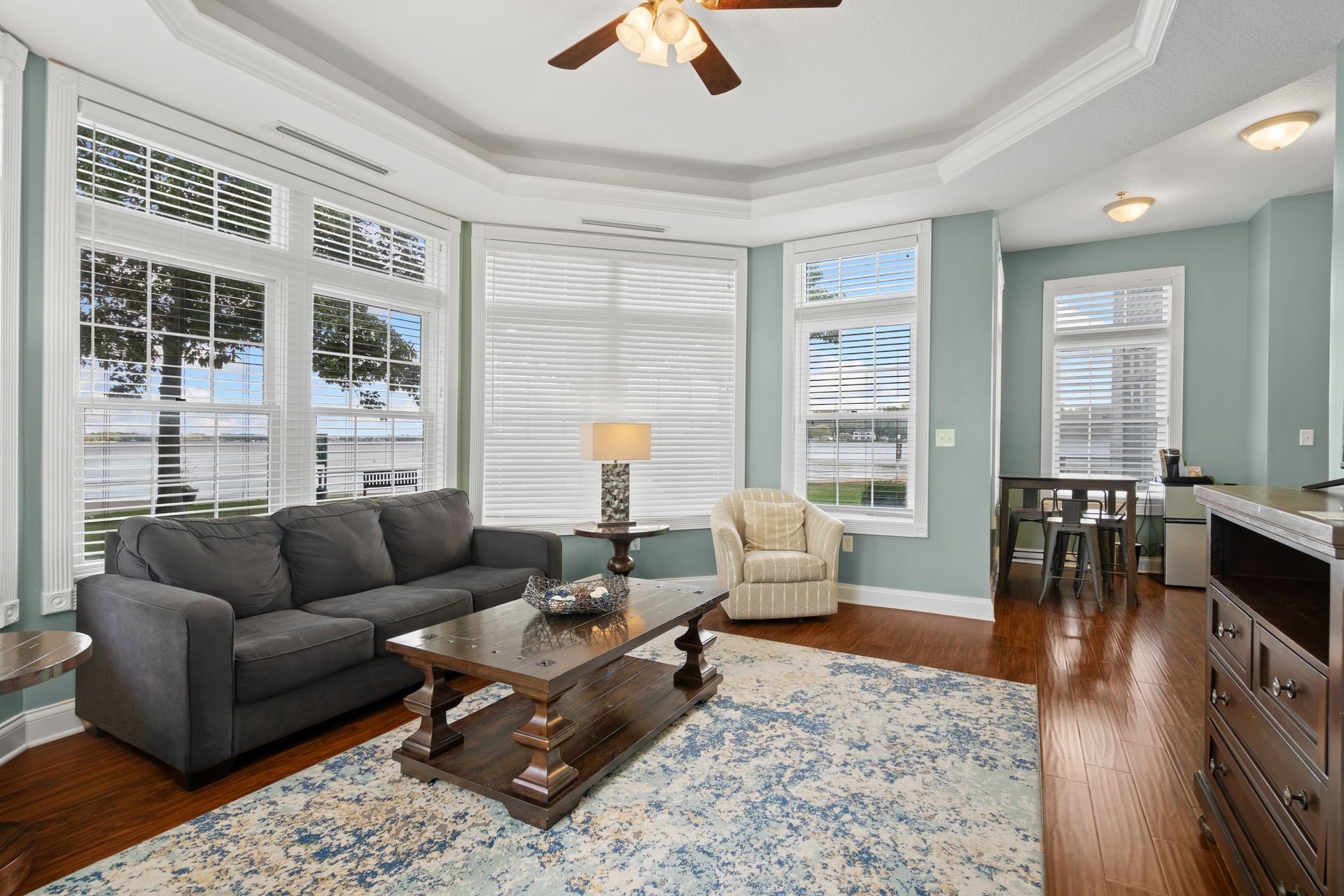 A living room with a couch , coffee table , chair and ceiling fan.