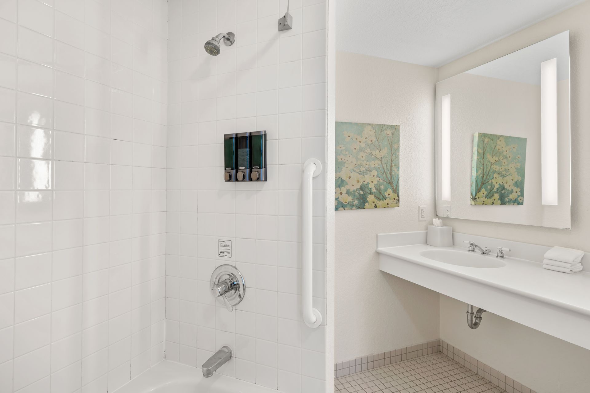 A bathroom with a tub , sink , mirror and shower.
