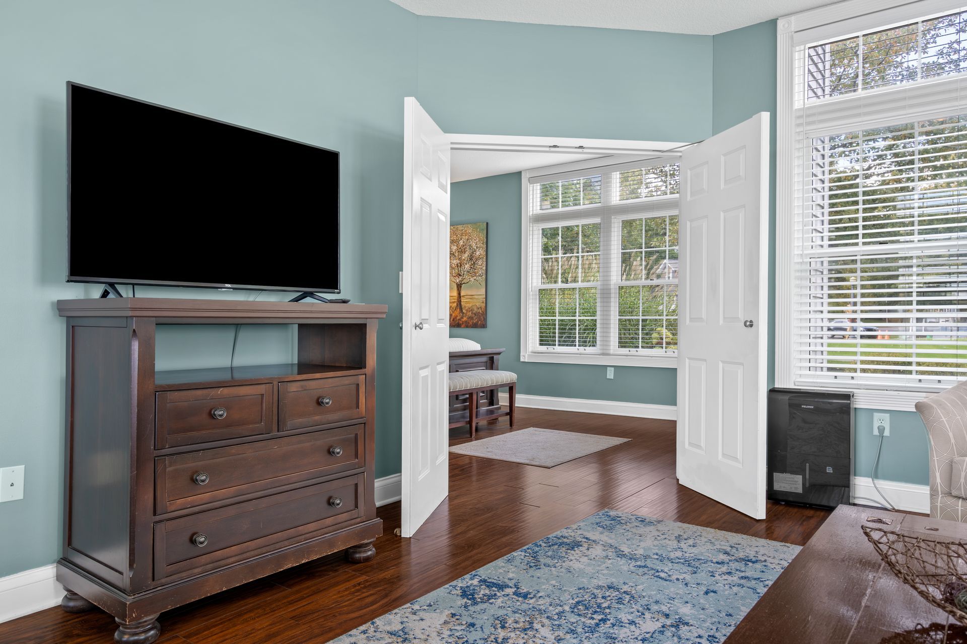 A living room with a dresser and a flat screen tv.