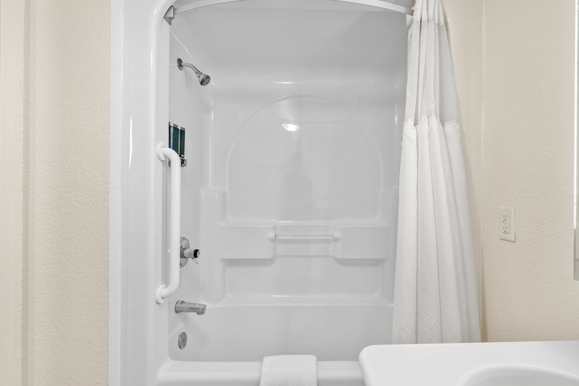A bathroom with a bathtub , sink and shower curtain.