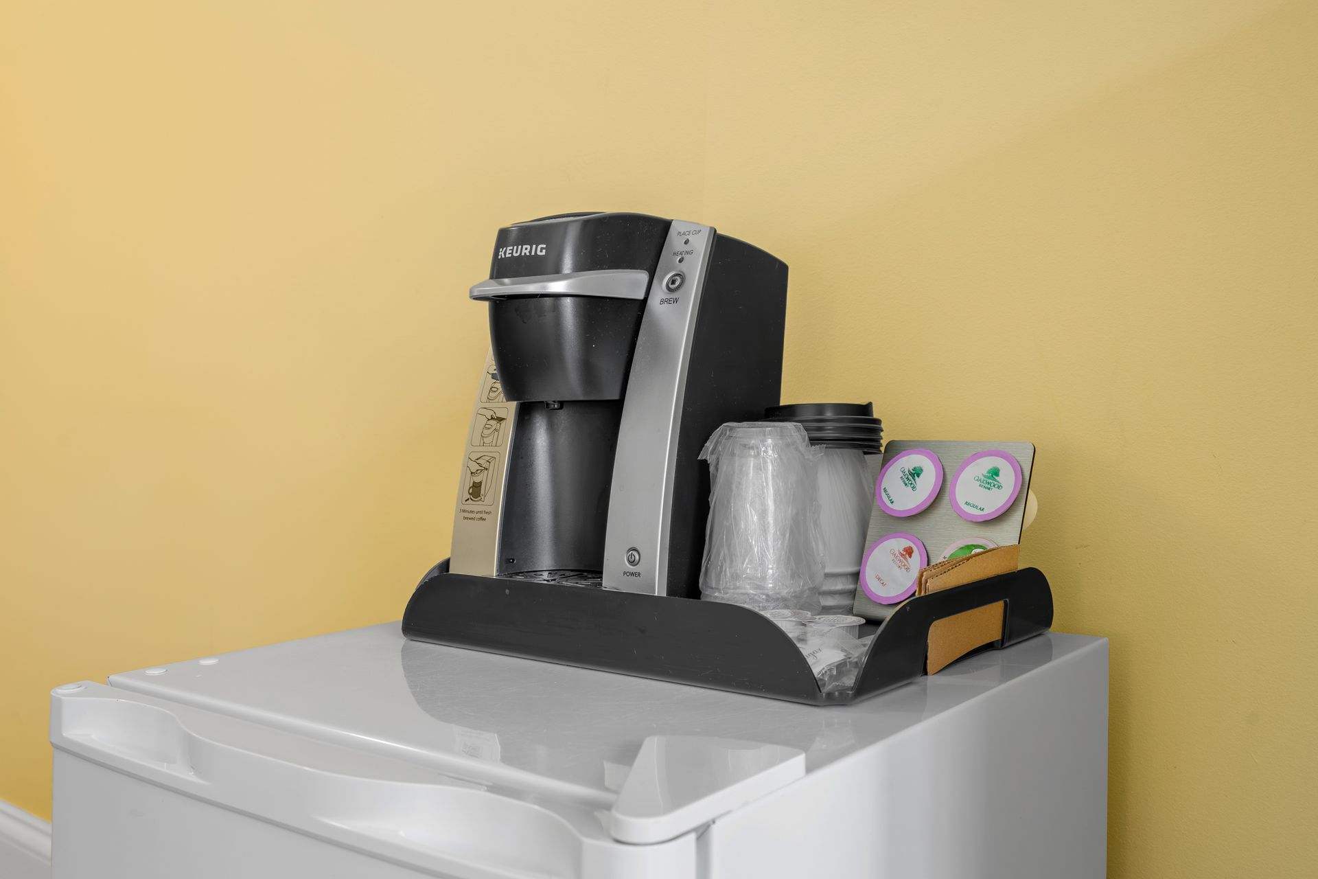 A coffee maker is sitting on top of a white refrigerator.