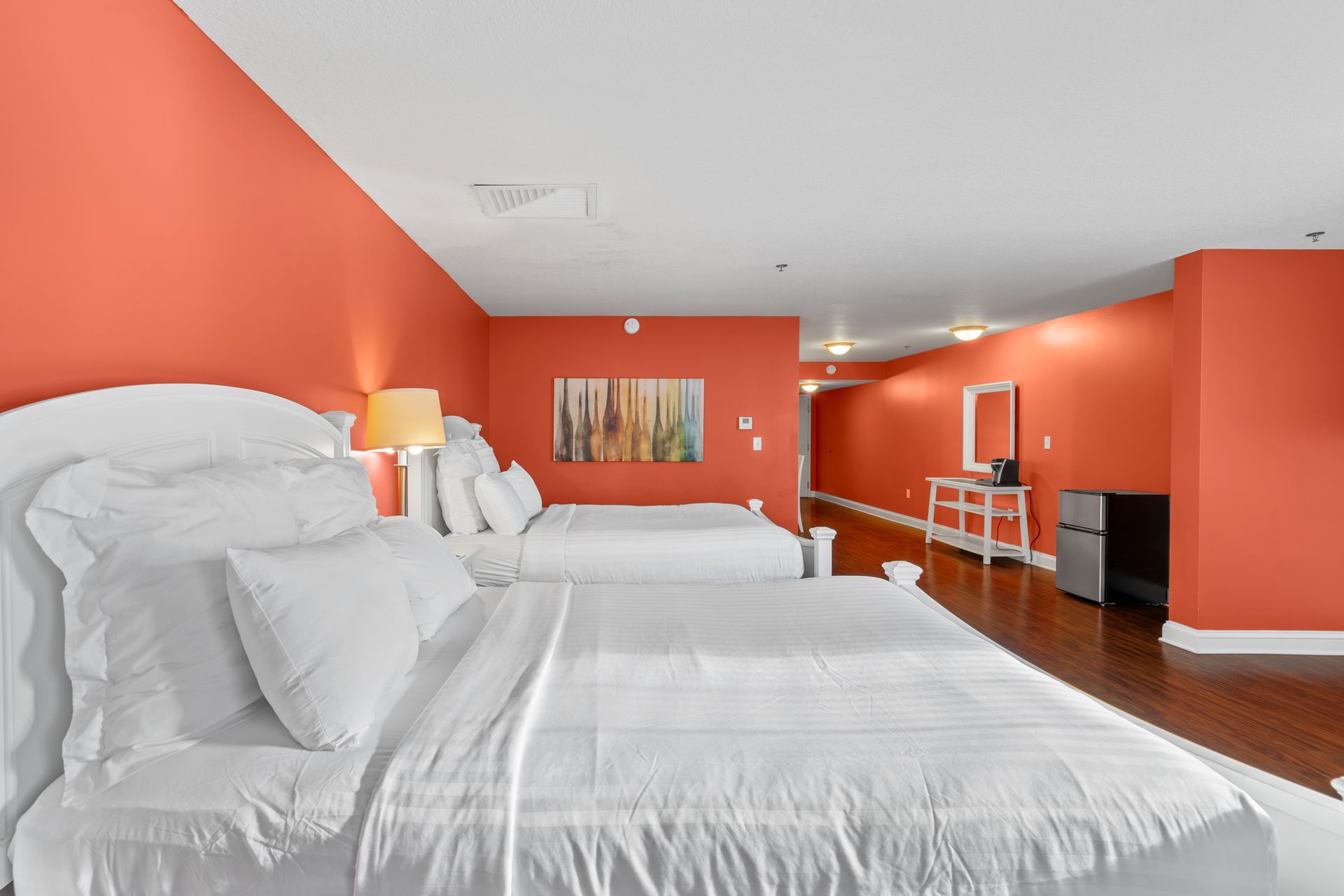 A hotel room with two beds and orange walls