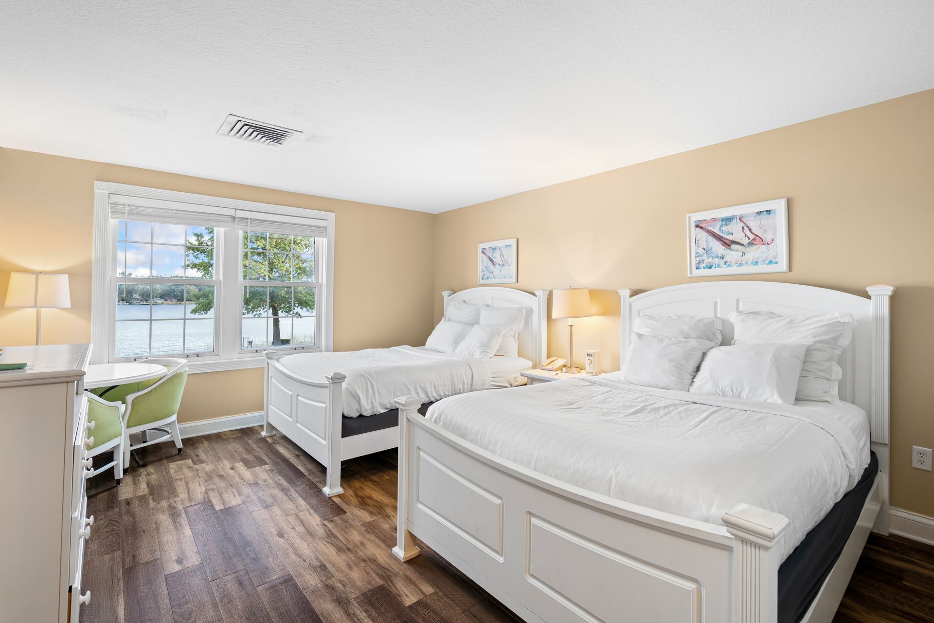 A bedroom with two beds , a desk and a window.
