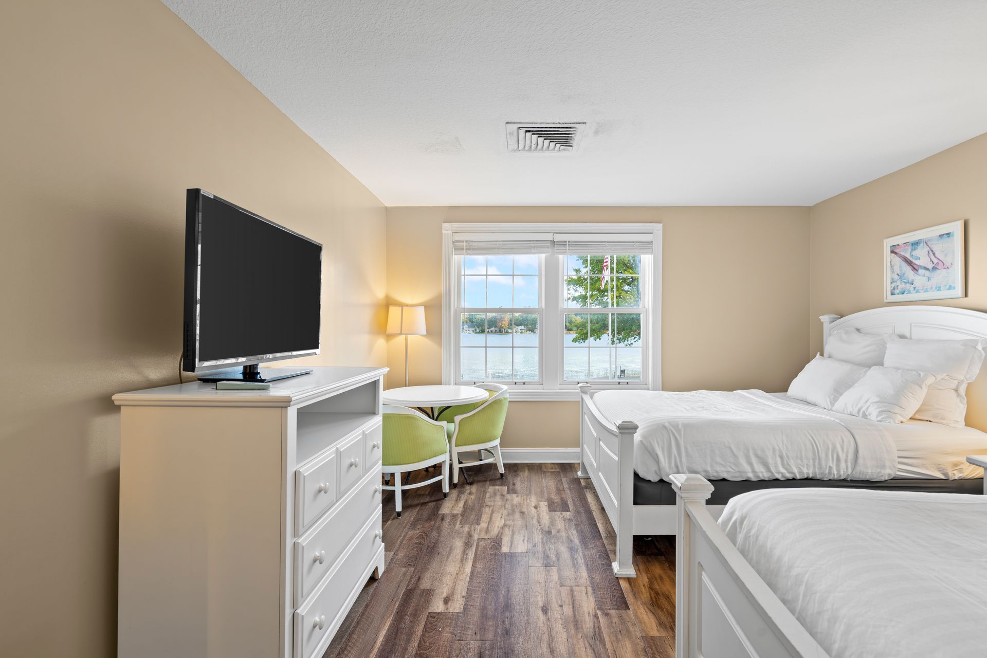 A hotel room with two beds and a flat screen tv.