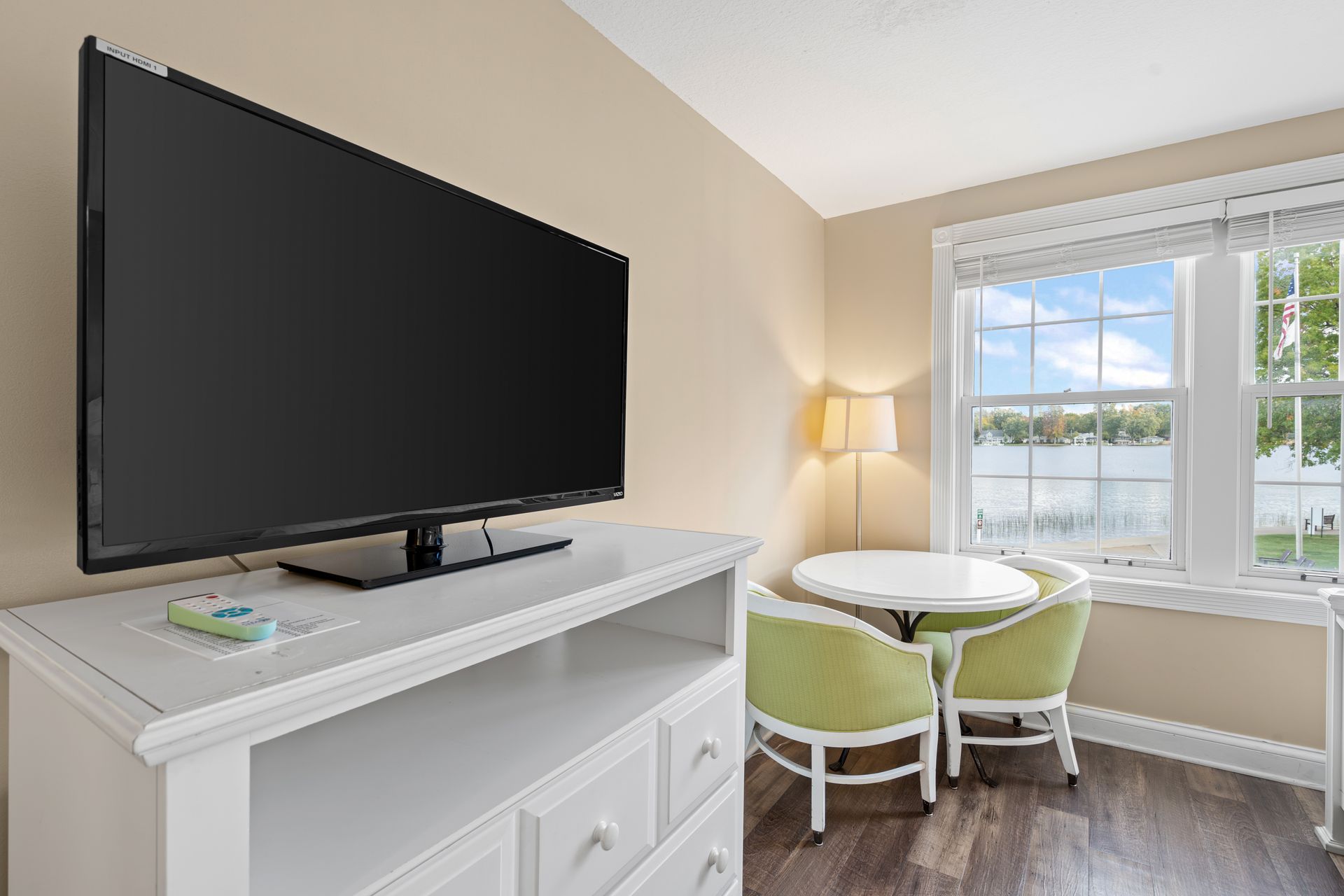 A large flat screen tv is sitting on top of a white entertainment center in a living room.