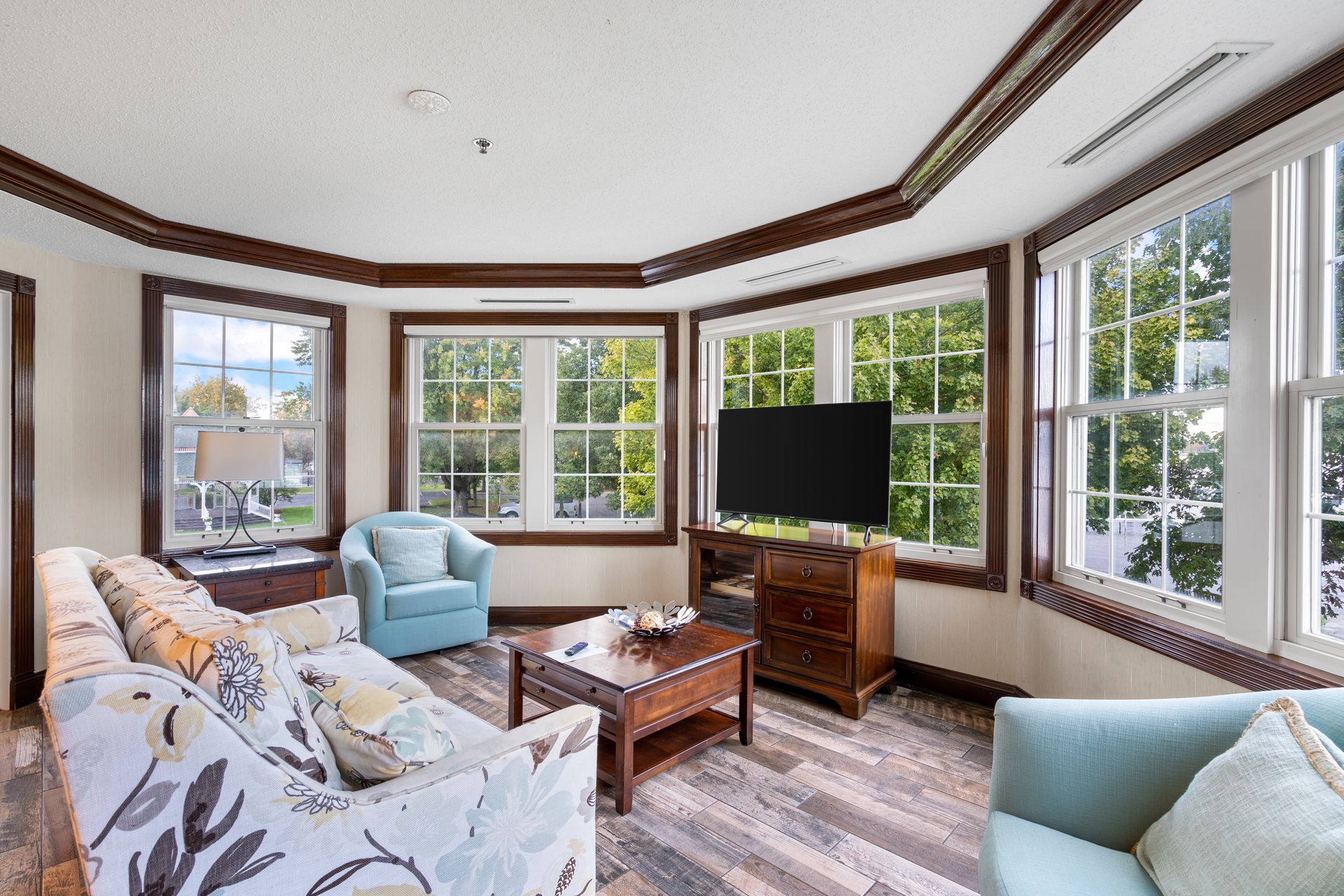 A living room with a couch , chair , coffee table and television.
