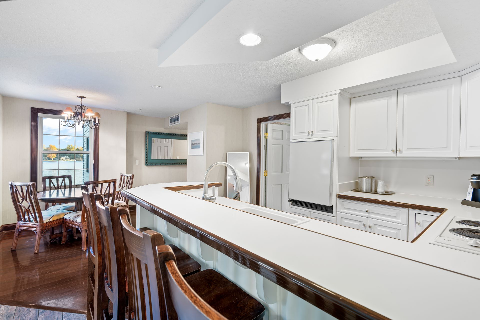A kitchen with white cabinets and a long counter