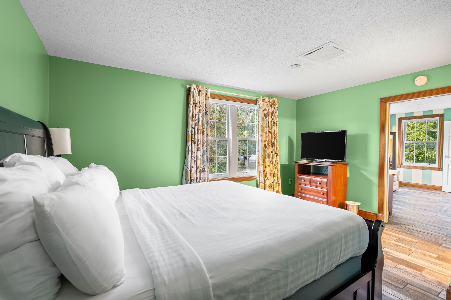A hotel room with a king size bed and a flat screen tv.
