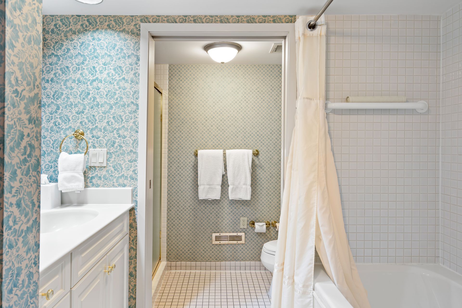 A bathroom with a sink , toilet , shower and bathtub.