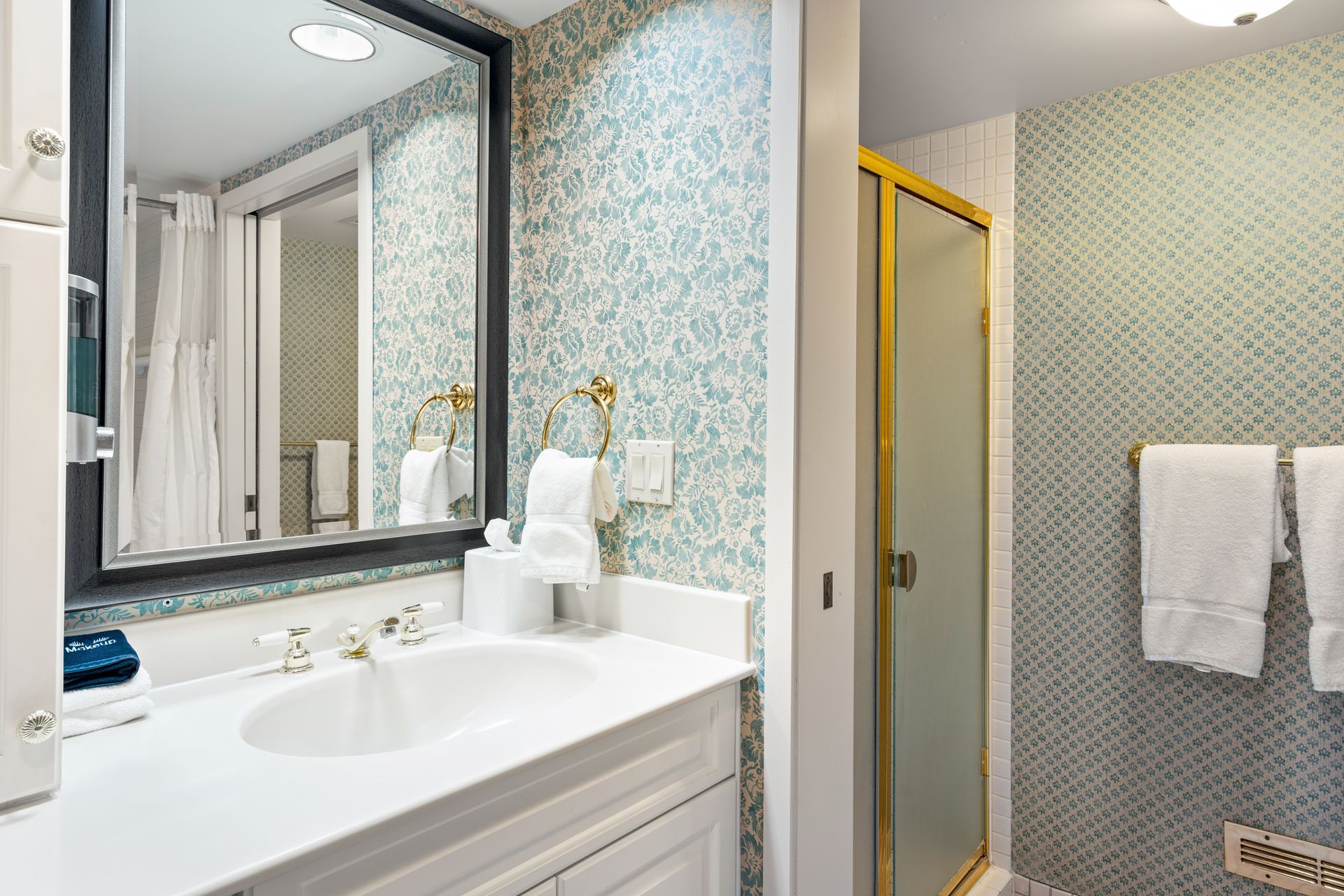 A bathroom with a sink , mirror , and shower.