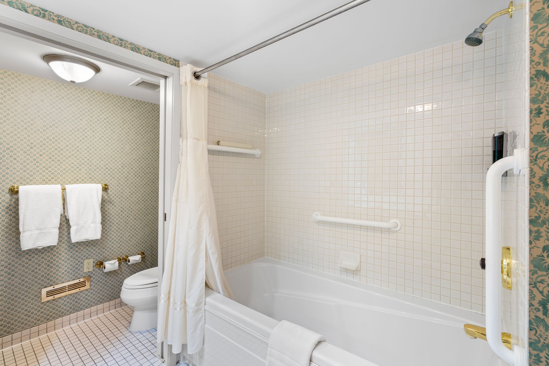 A bathroom with a tub , toilet and shower.