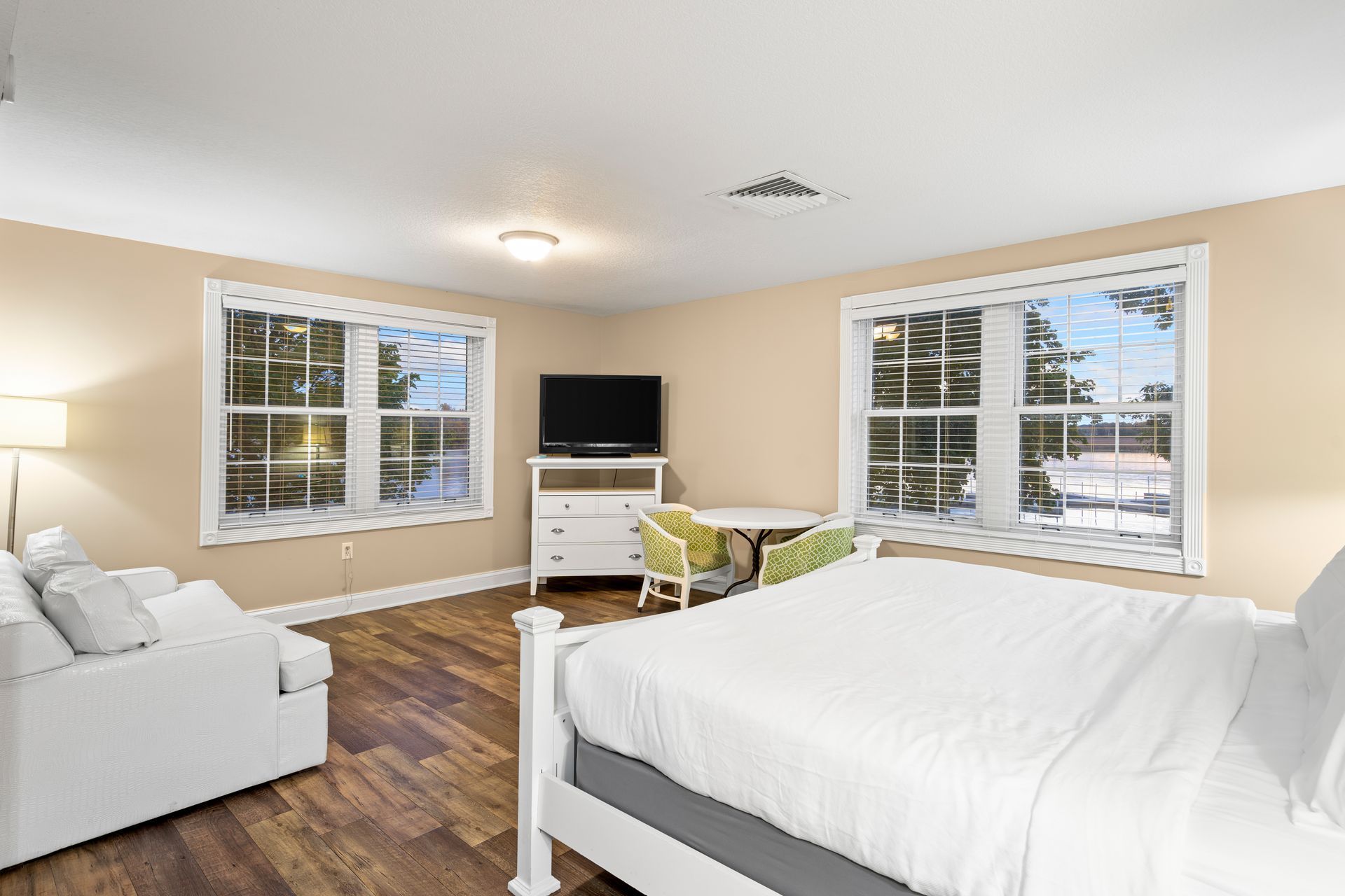 A bedroom with a king size bed , a couch , and a television.