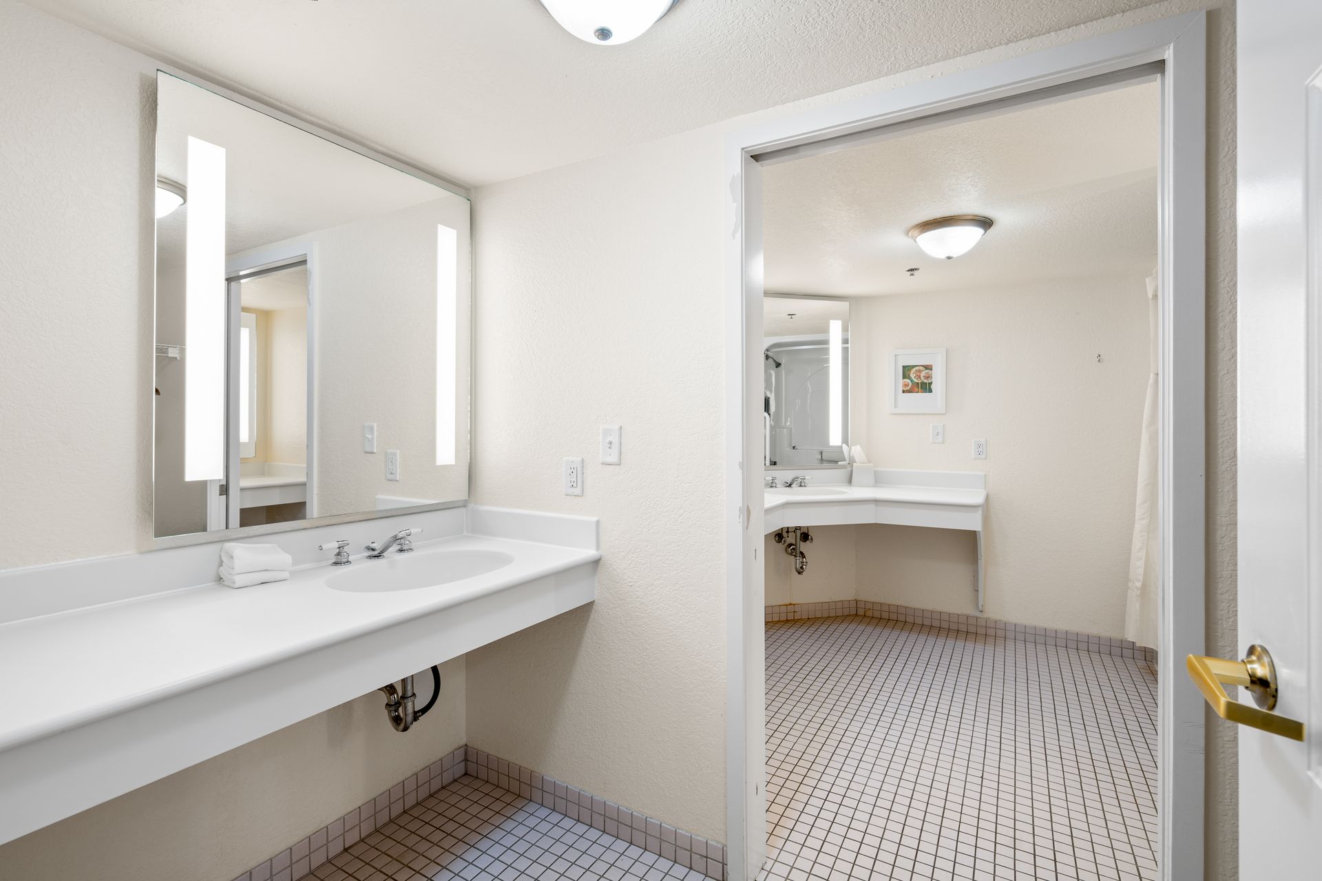 A bathroom in a hotel room with a sink and mirror.