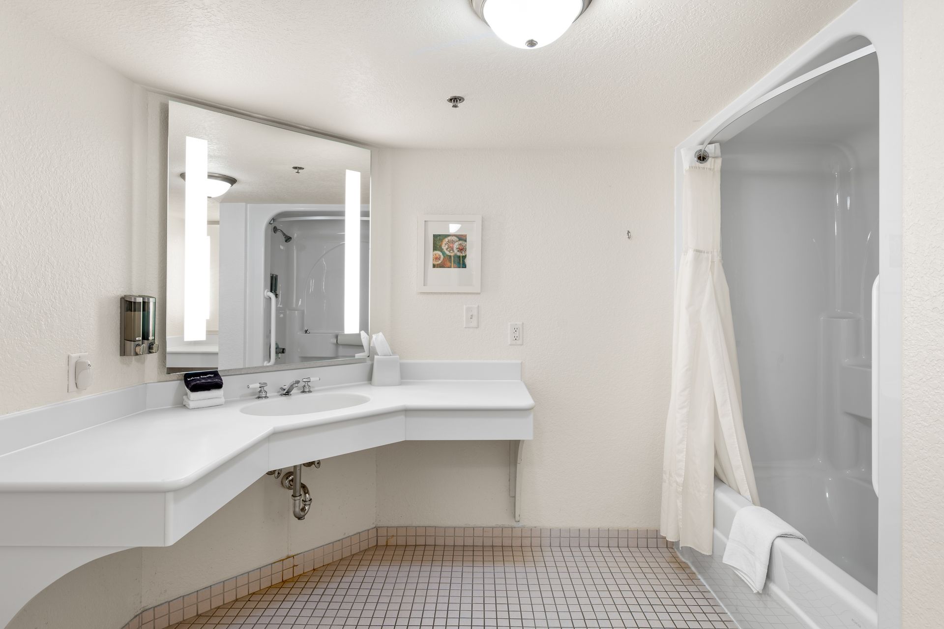 A bathroom with a sink , mirror , tub and shower.