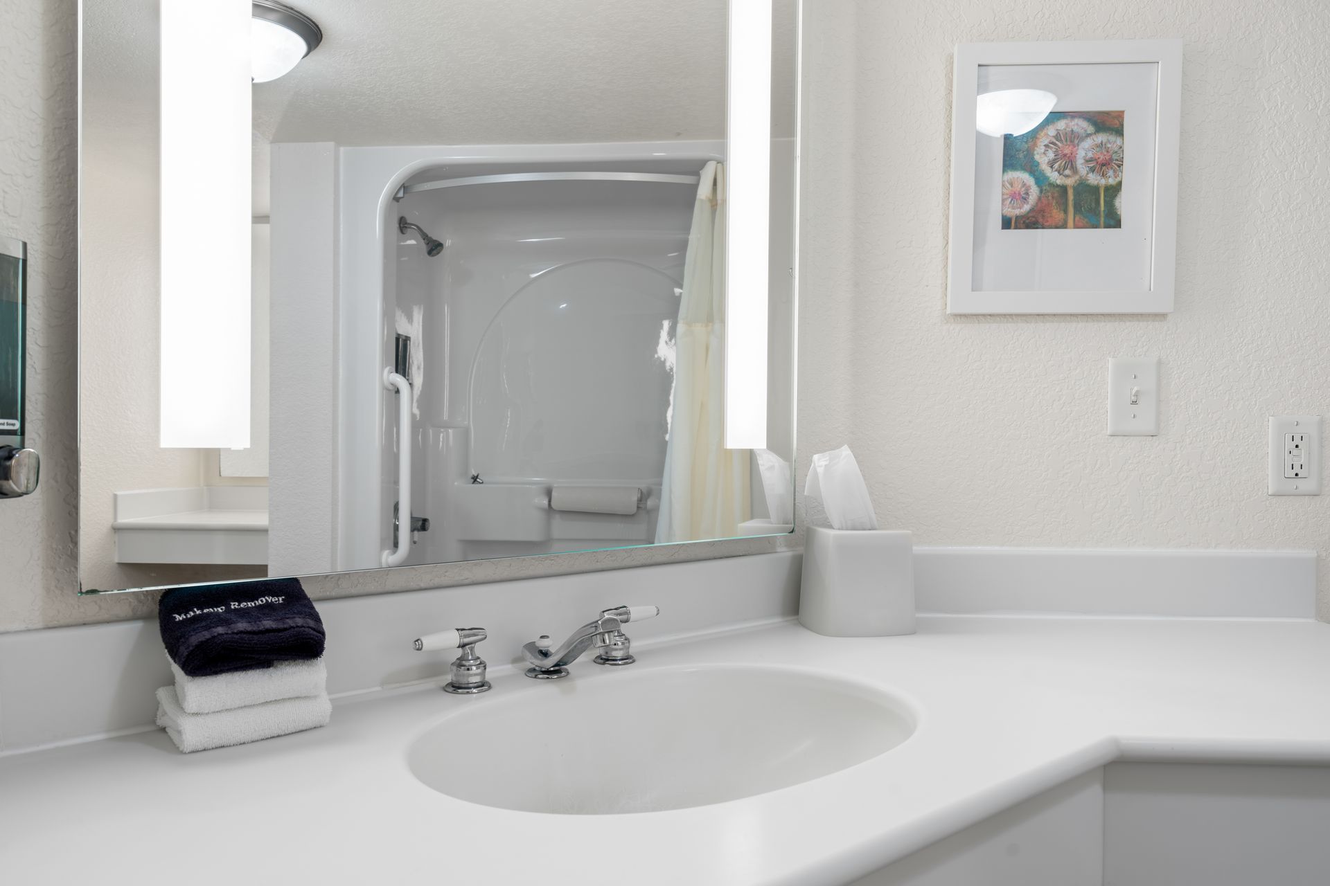 A bathroom with a sink , mirror and picture on the wall.