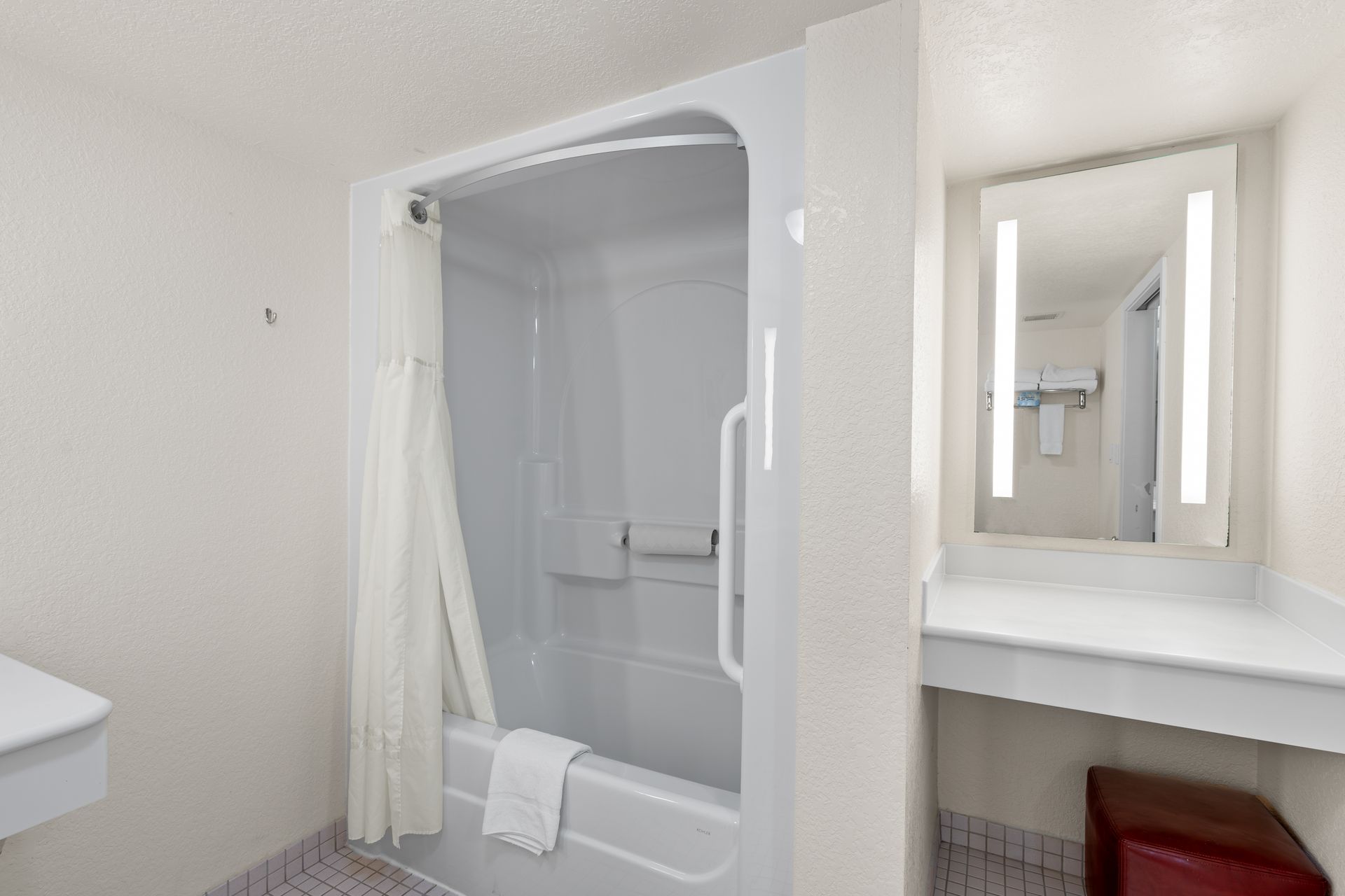 A bathroom with a bathtub and a mirror.