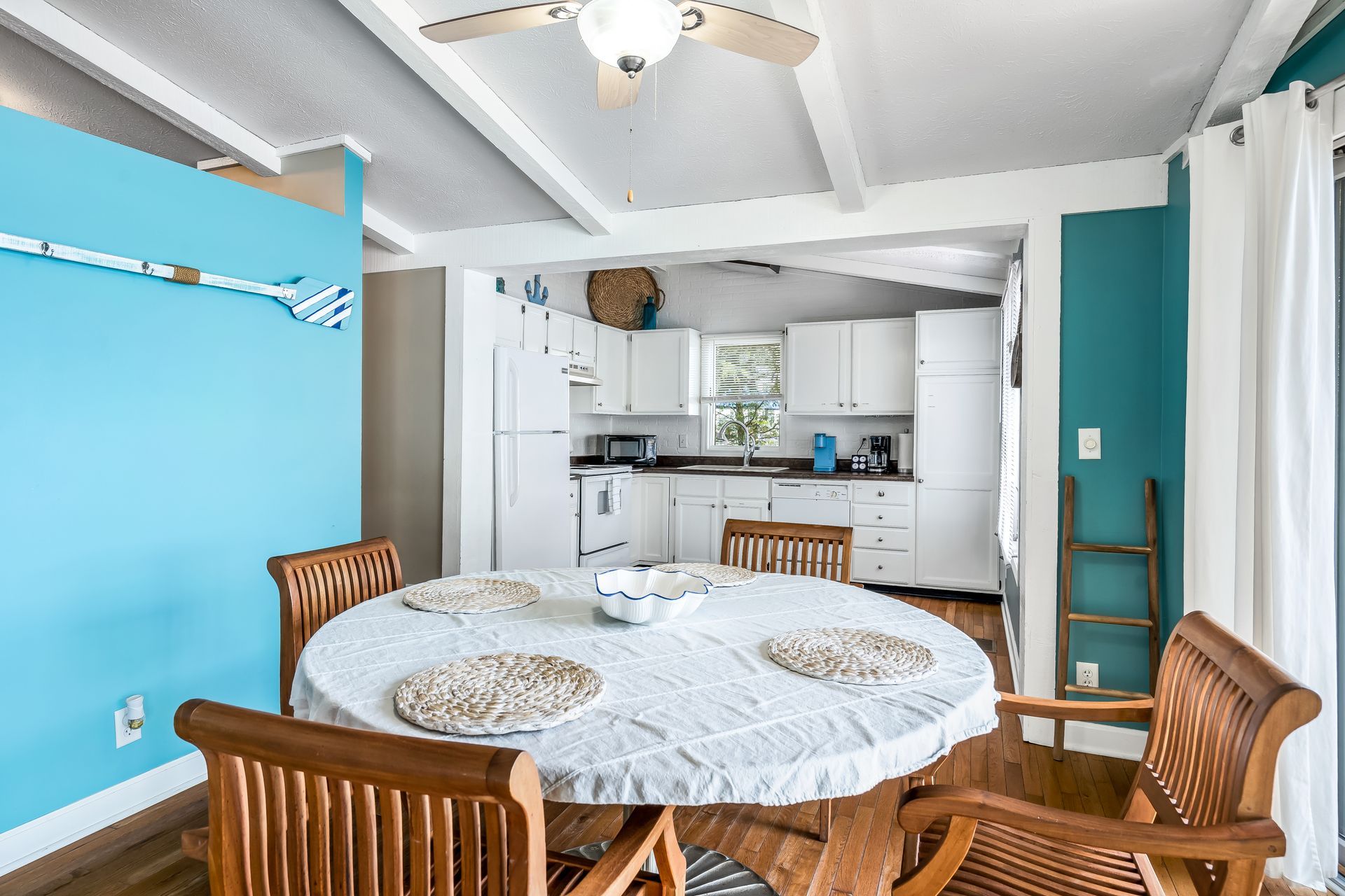 A dining room with a table and chairs and a ceiling fan.