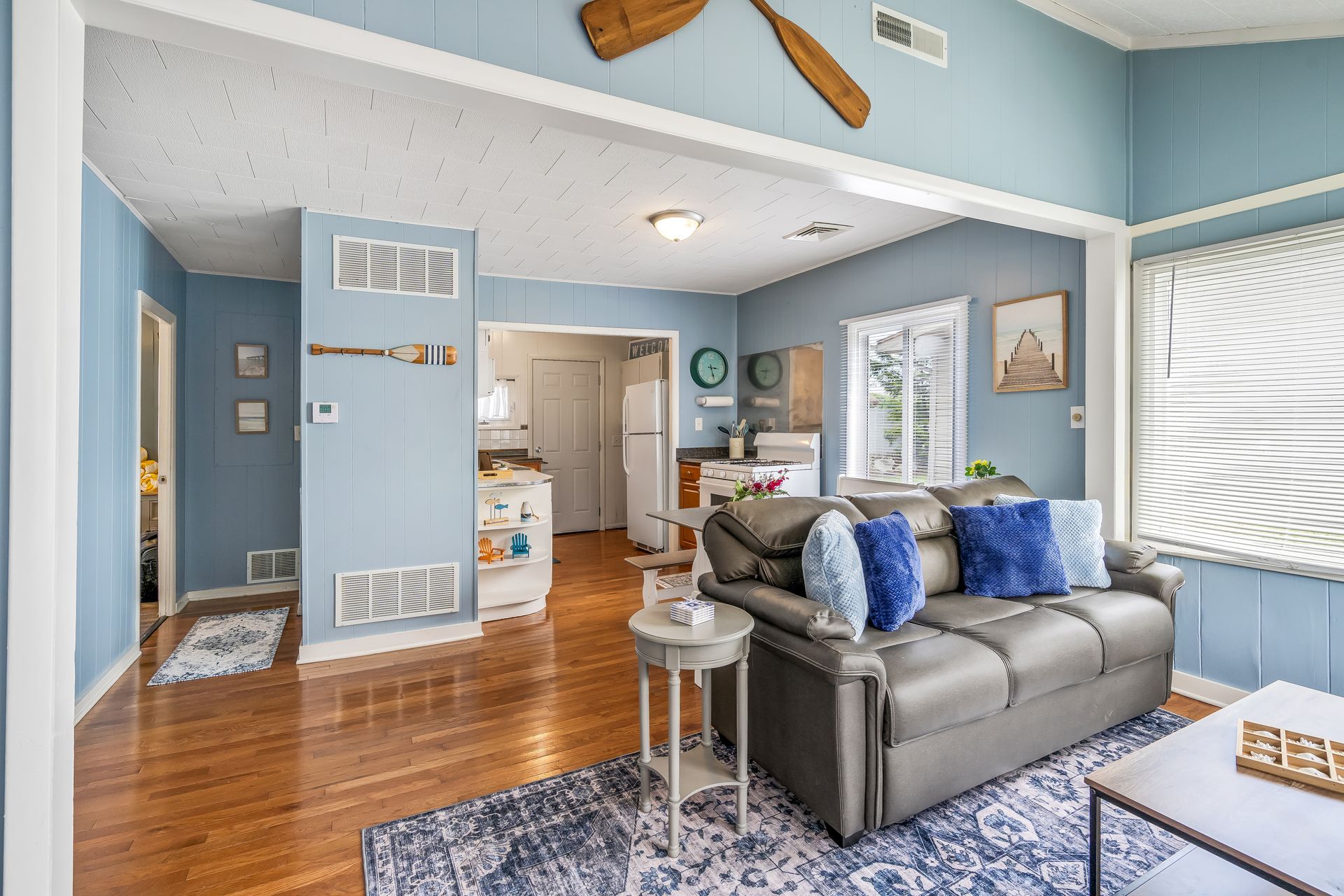 A living room with a couch , table , rug and blue walls.