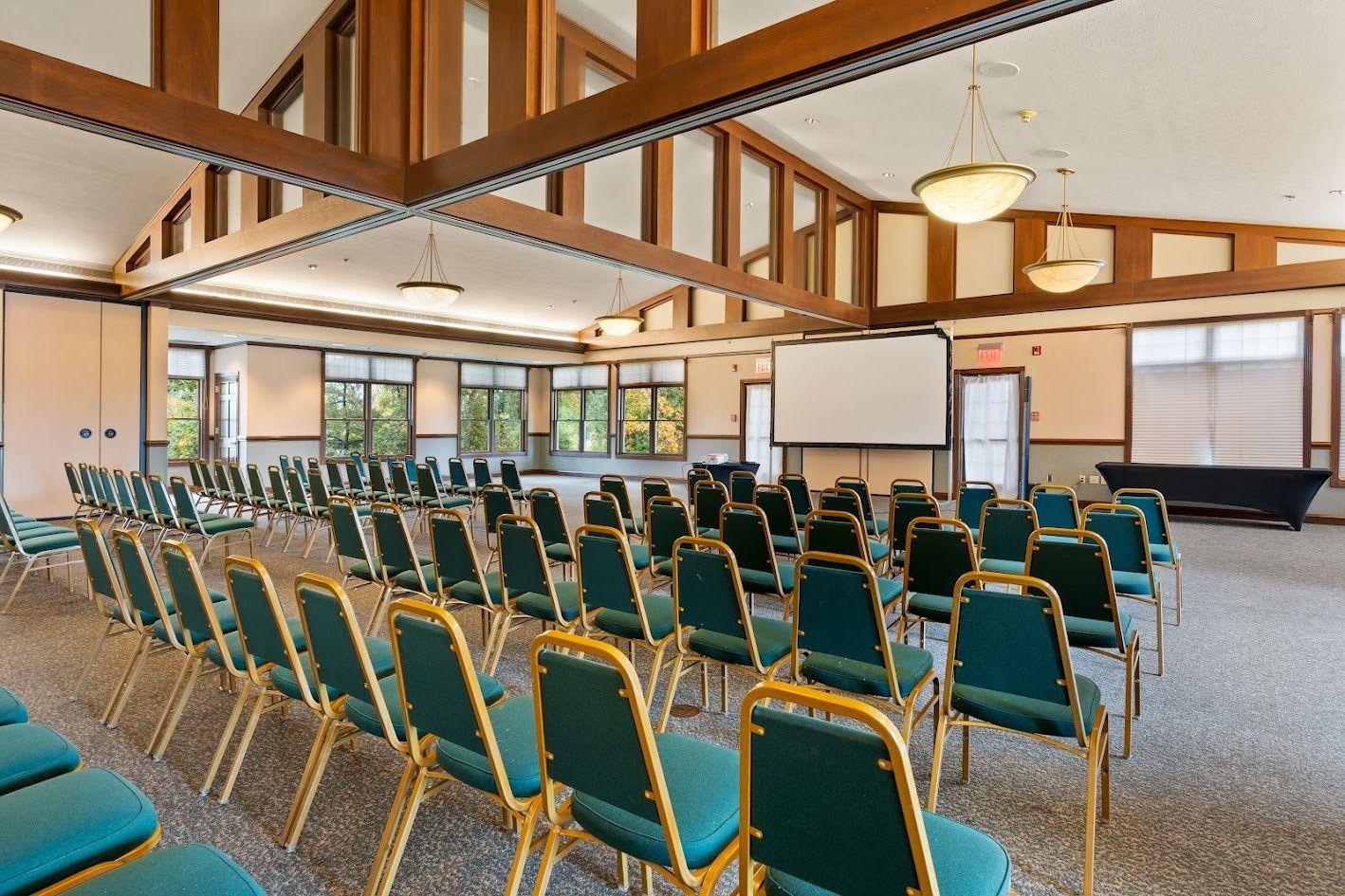 A large room with rows of chairs and a projector screen.