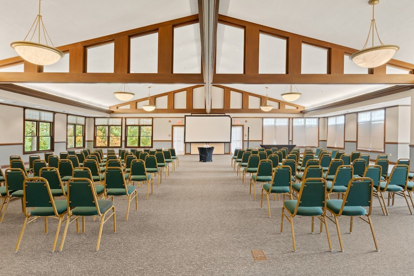 A large room with rows of chairs and a projector screen