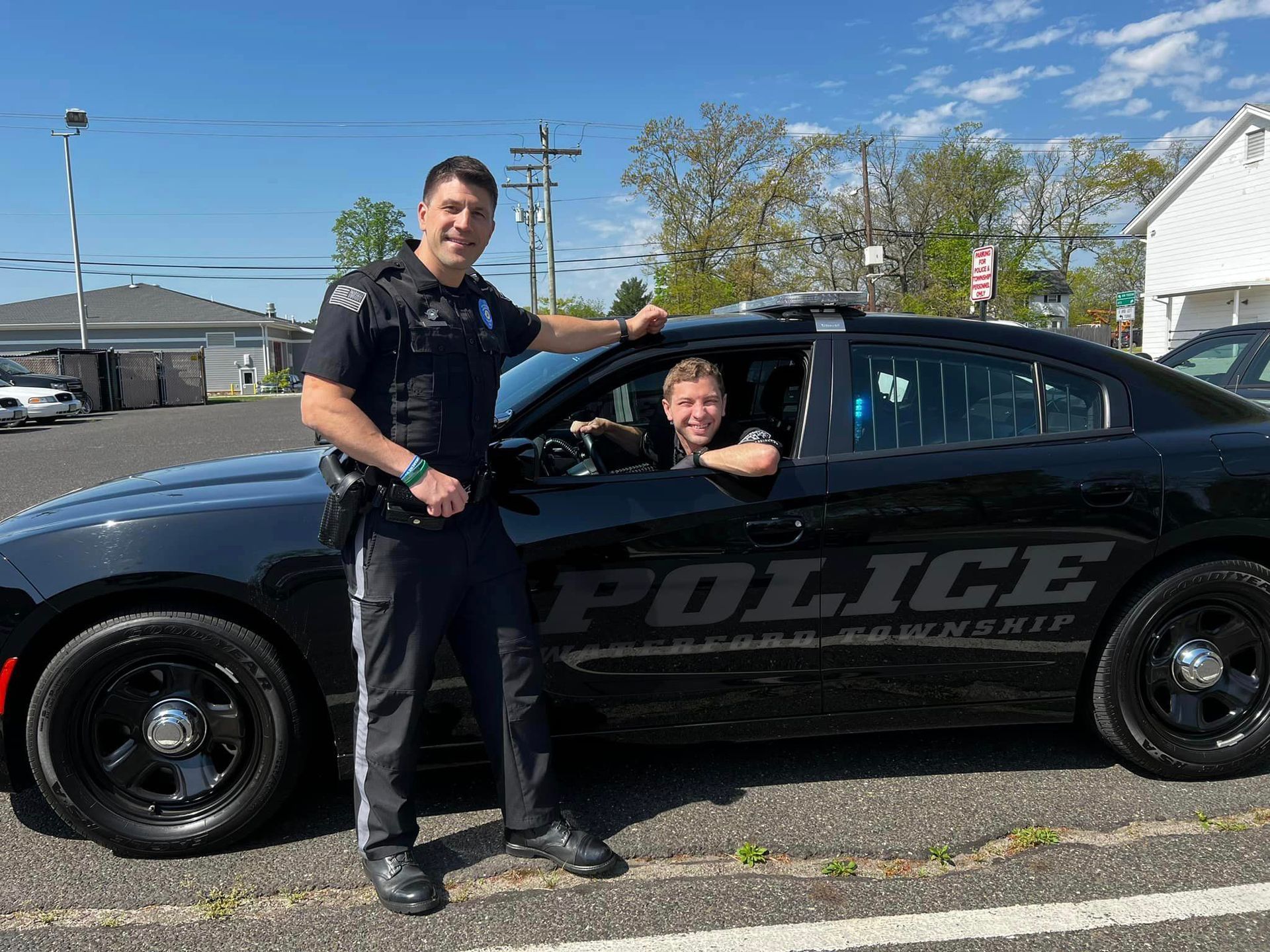 two police officers standing next to a police car